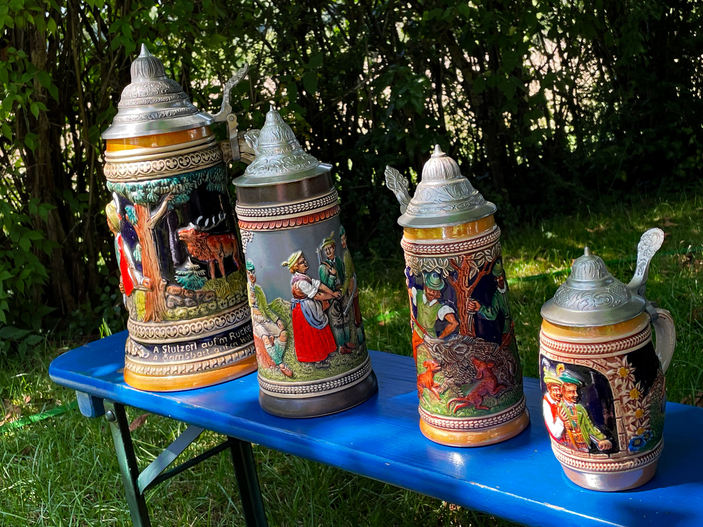 Four vintage German beer steins with pewter lids displayed together