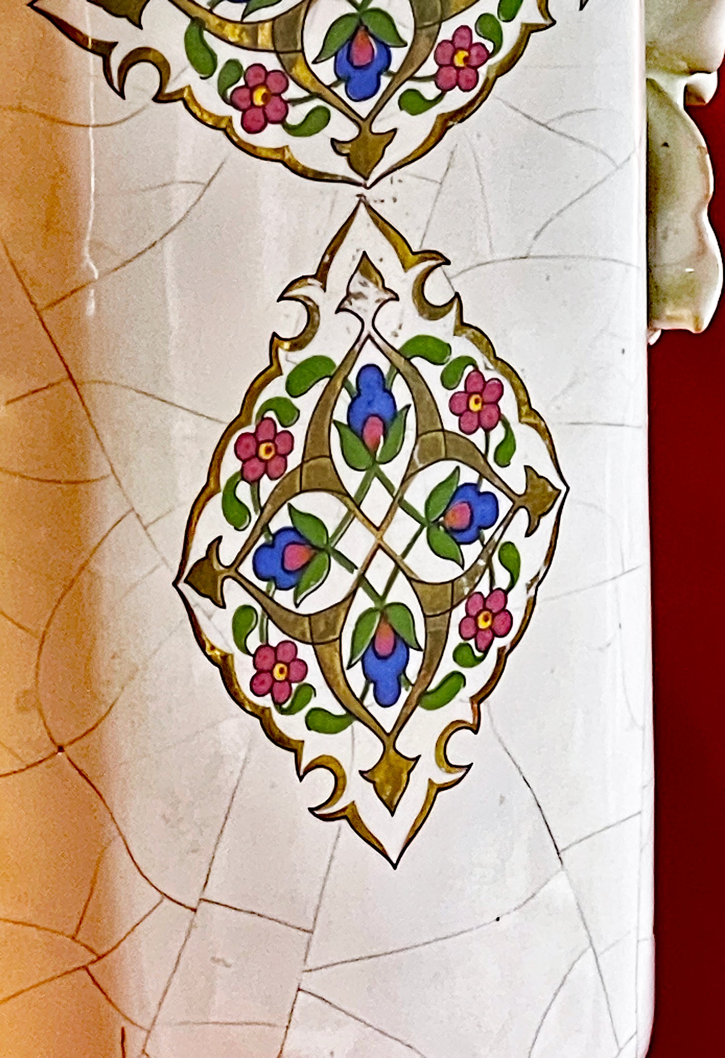 Detail of hand applied porcelain roses and painted floral cartouche on a vase