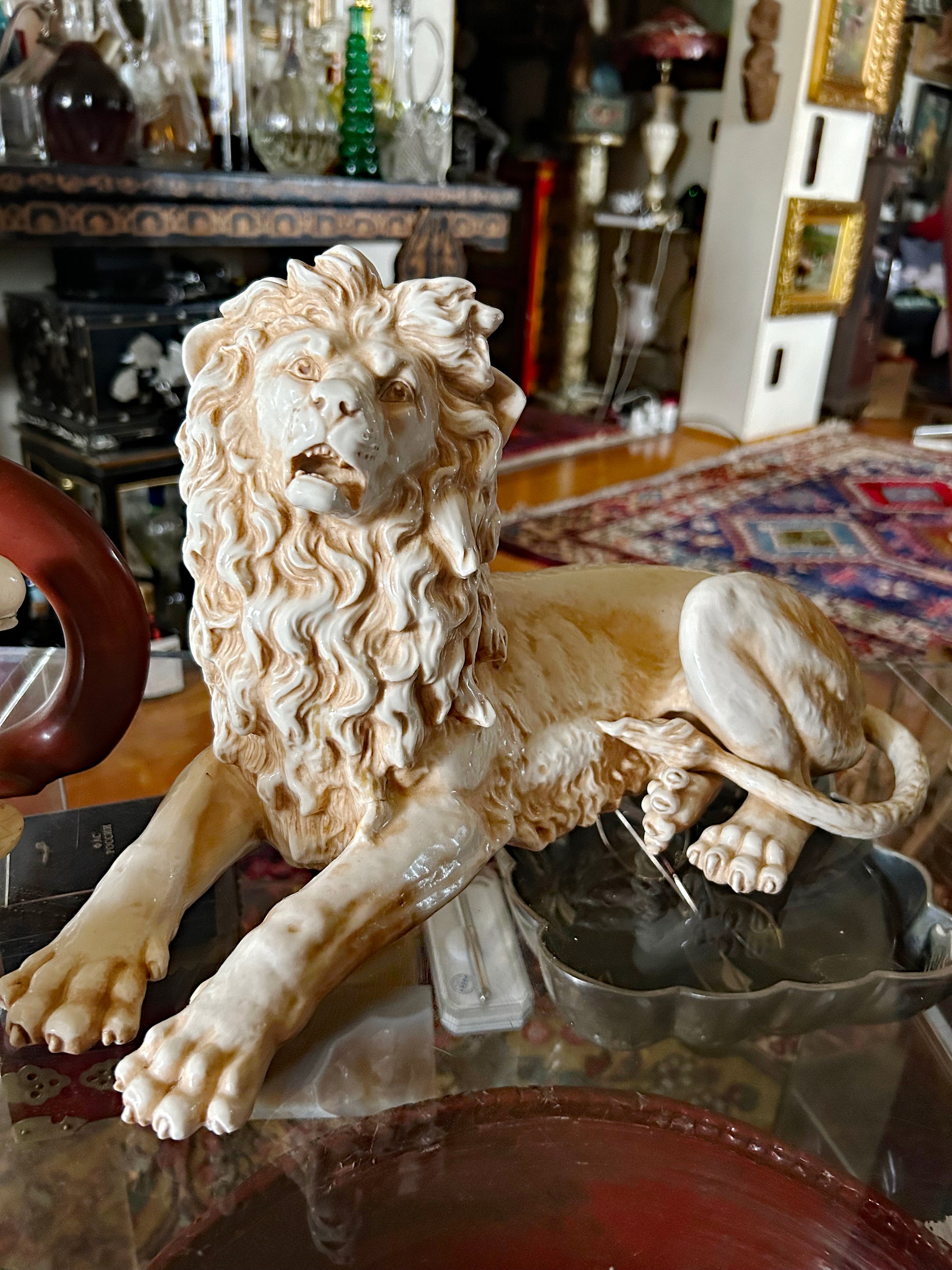 Porcelain lion figurine three-quarter view showing modelled body and paws