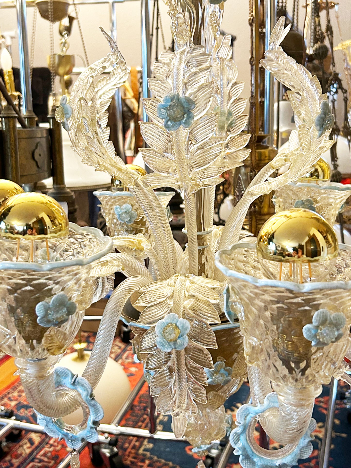 Close detail of a Murano candle cup with gold sphere and blue glass blossom