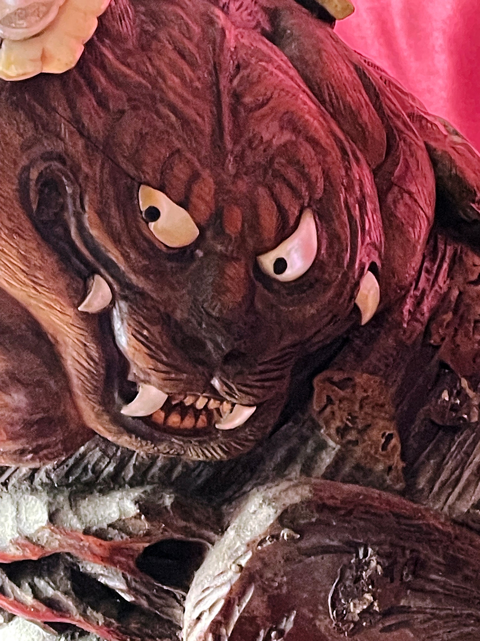 Detail of fierce mythical beast relief carving with bone fangs