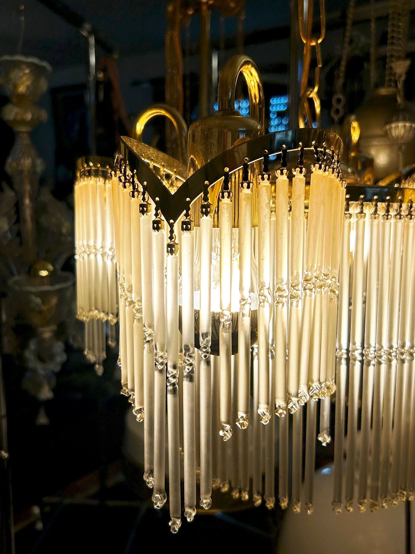 Illuminated detail of faceted glass drops and cream crystal rods