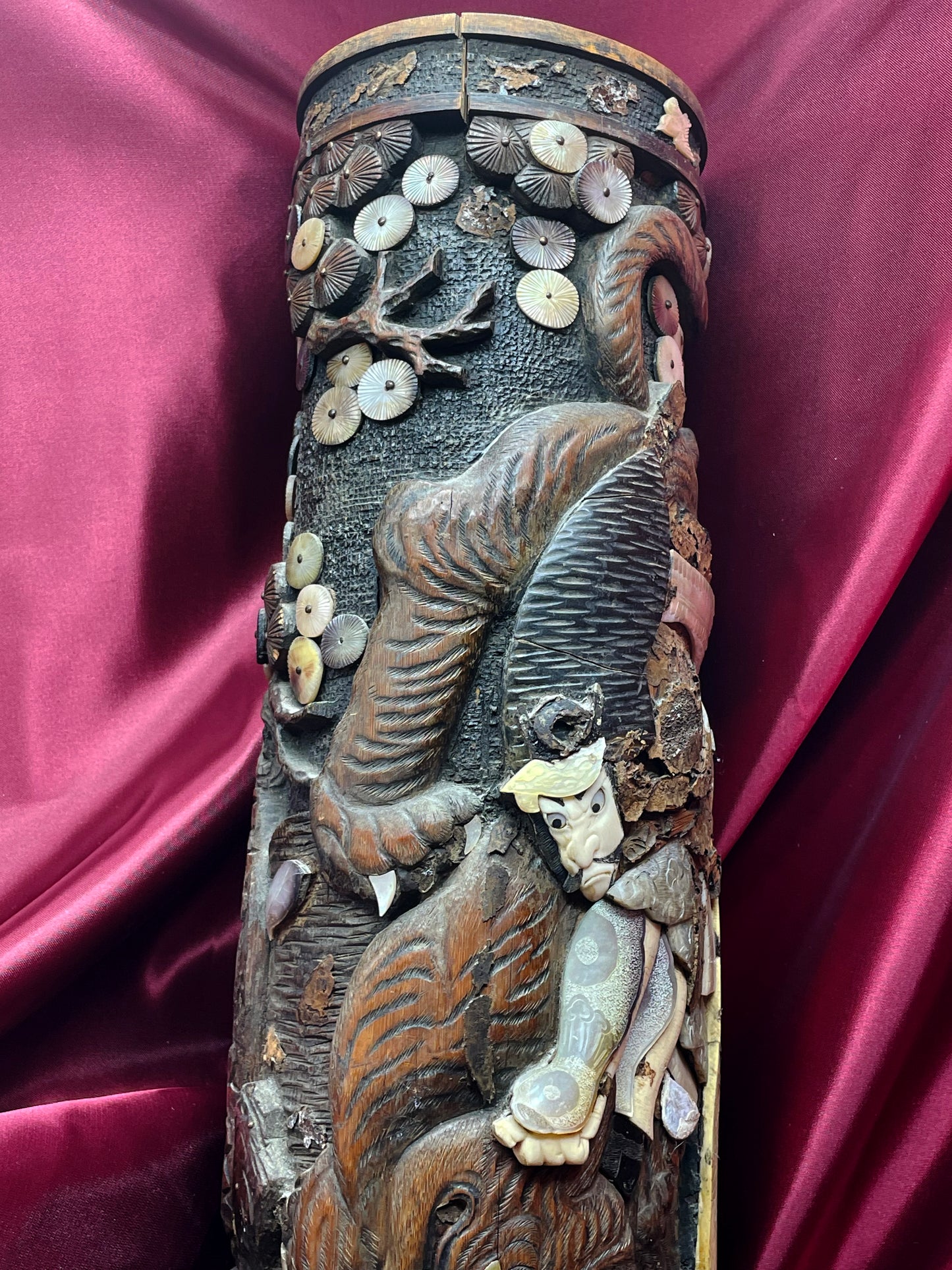 Carved scene wrapping the hardwood cylinder