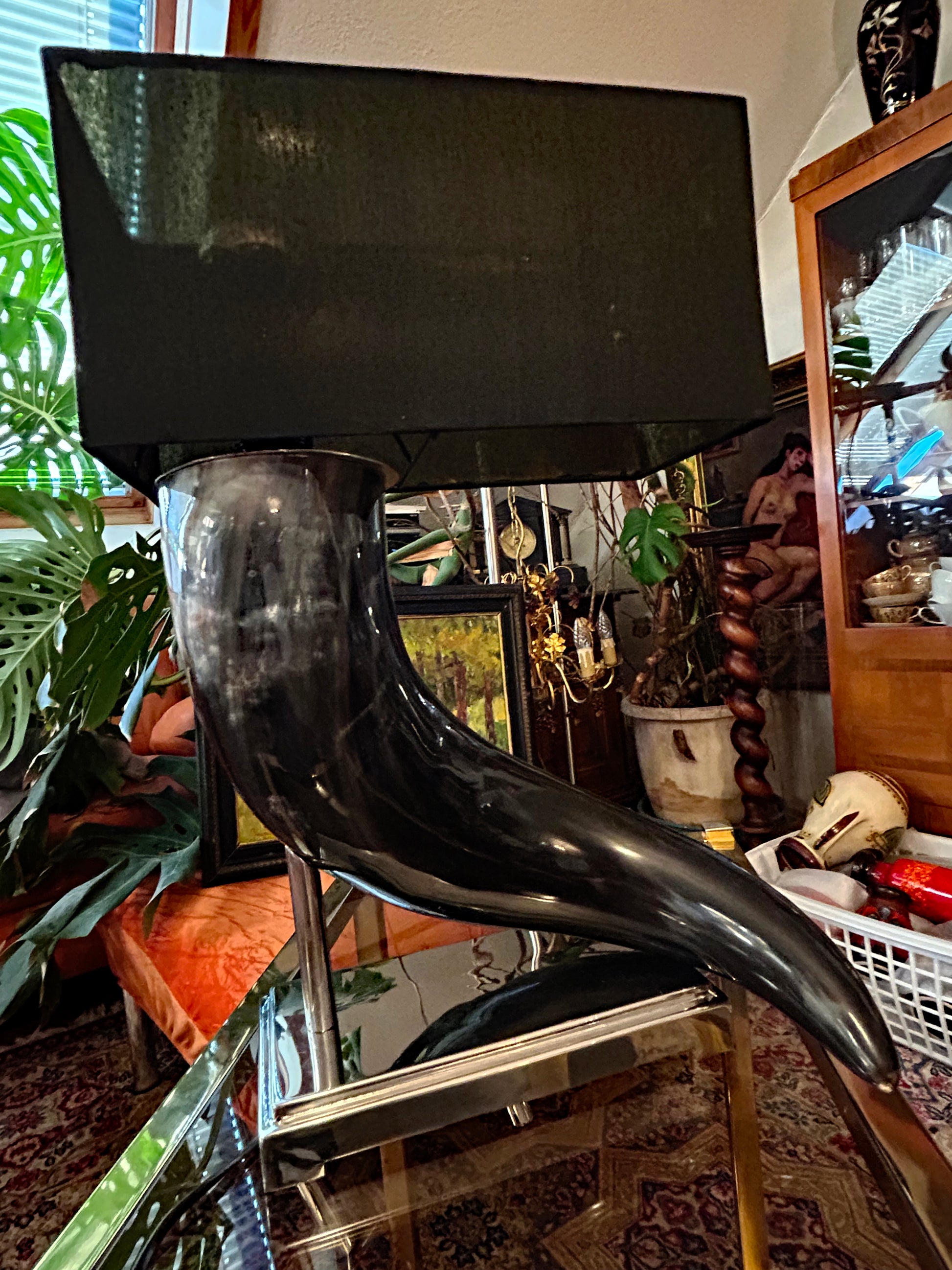 Three-quarter view of the sculptural horn table lamp showing the sweeping horn form and rectangular shade