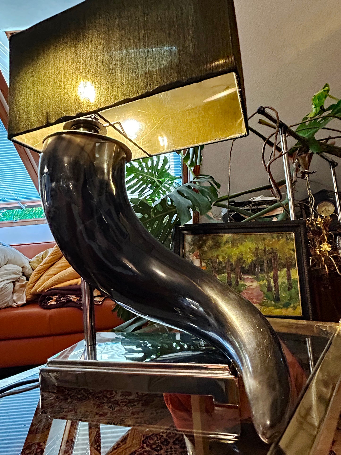 Horn table lamp illuminated, showing the warm gold-lined shade glow and polished horn surface