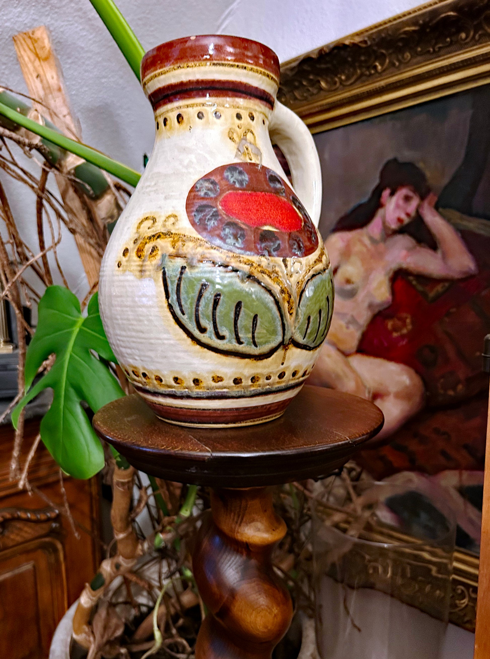 West German folk-art pottery jug, three-quarter view showing painted shield and handle