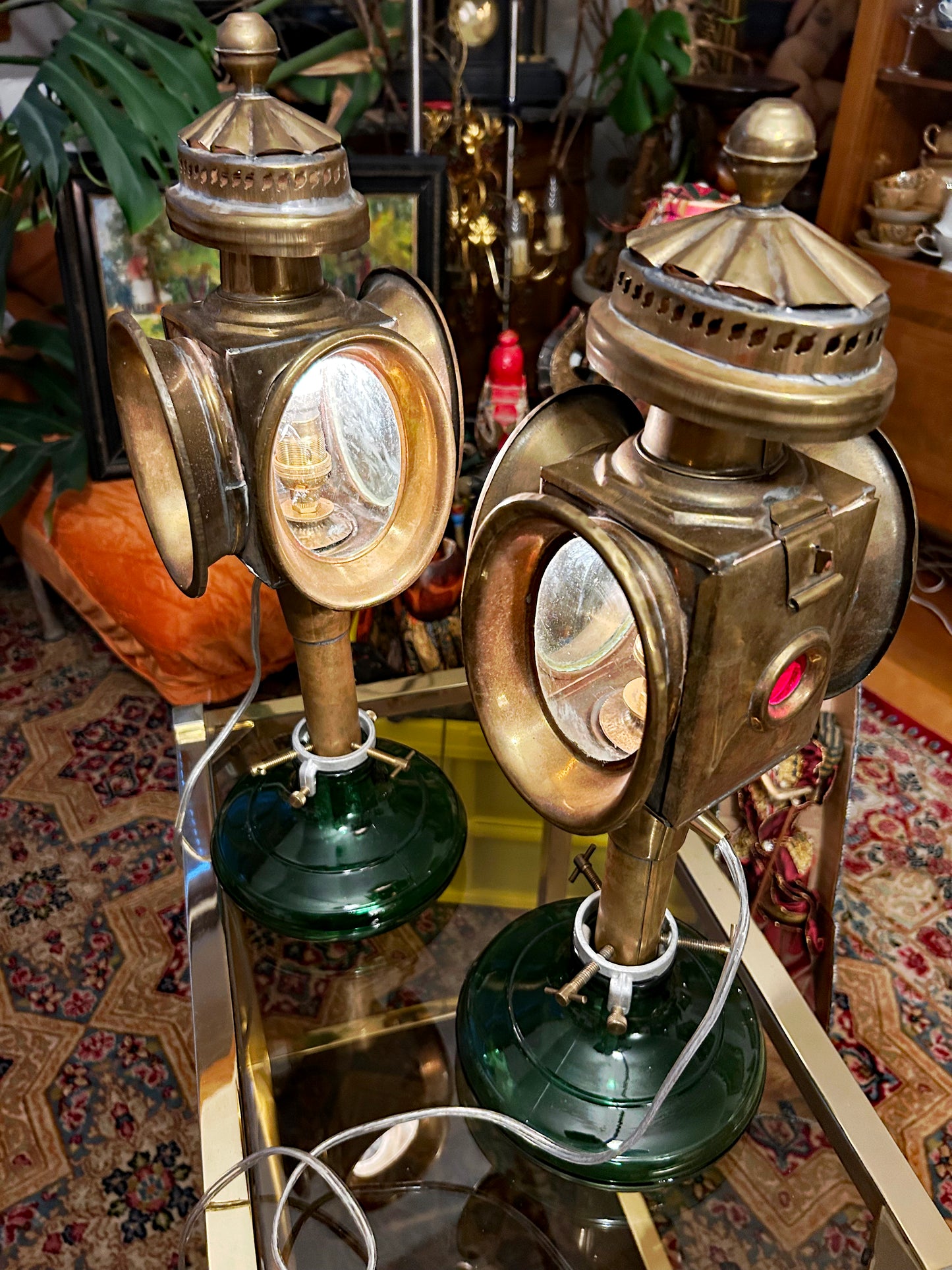 Two electrified brass carriage lamps with green glass bases and ruby side jewels
