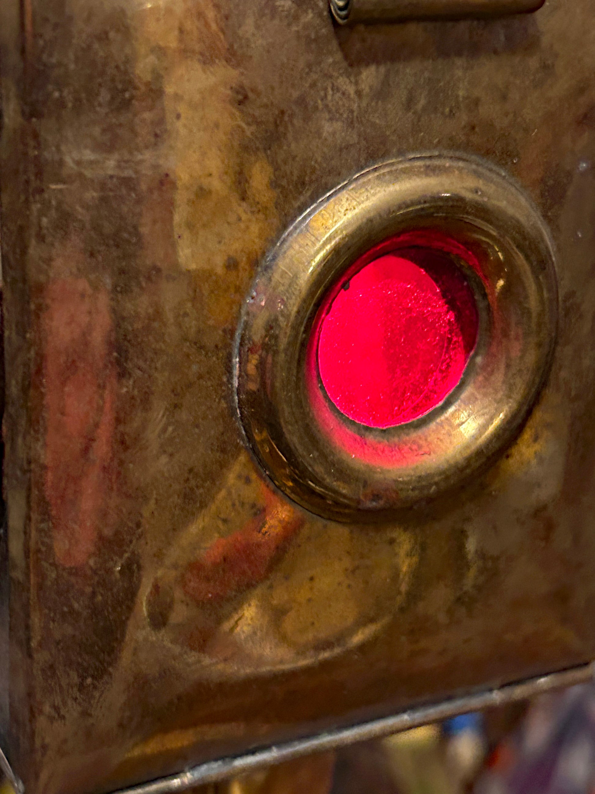 Close-up of the ruby-red side warning jewel set in brass
