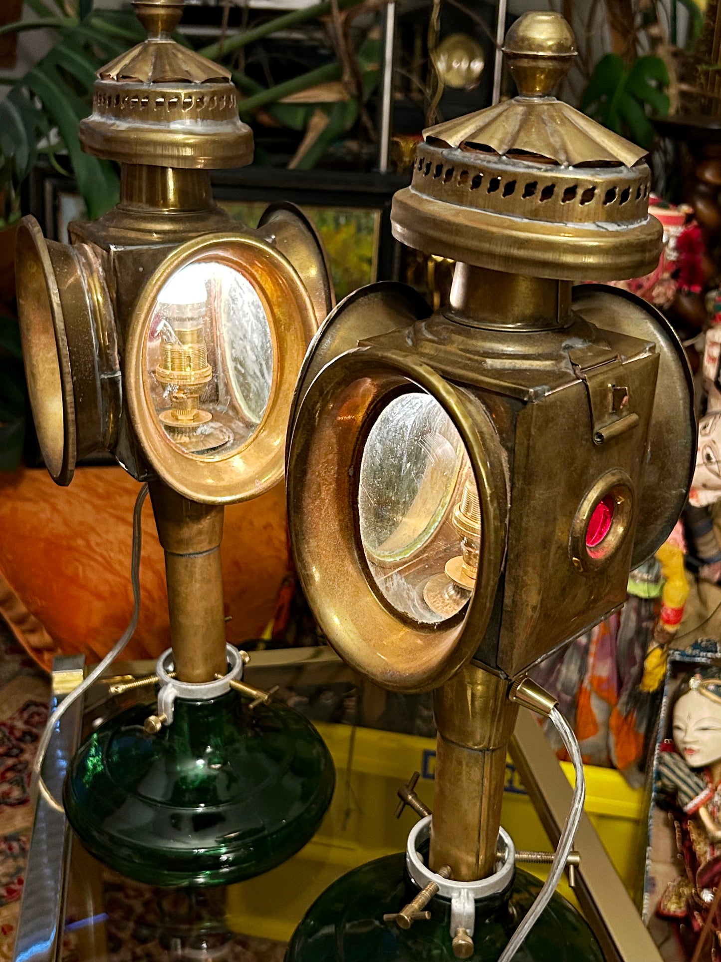 Pair of antique brass carriage lamps on green glass bases, front three-quarter view