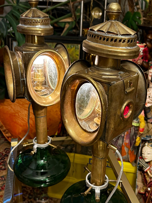 Pair of antique brass carriage lamps on green glass bases, front three-quarter view