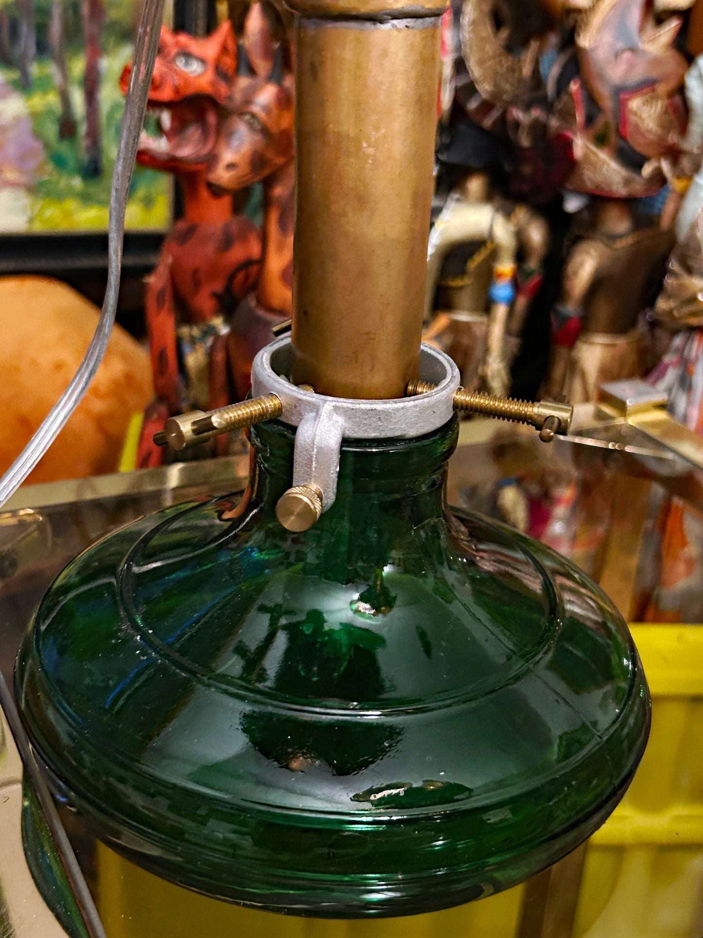 Detail of the green pressed-glass base and brass mounting hardware