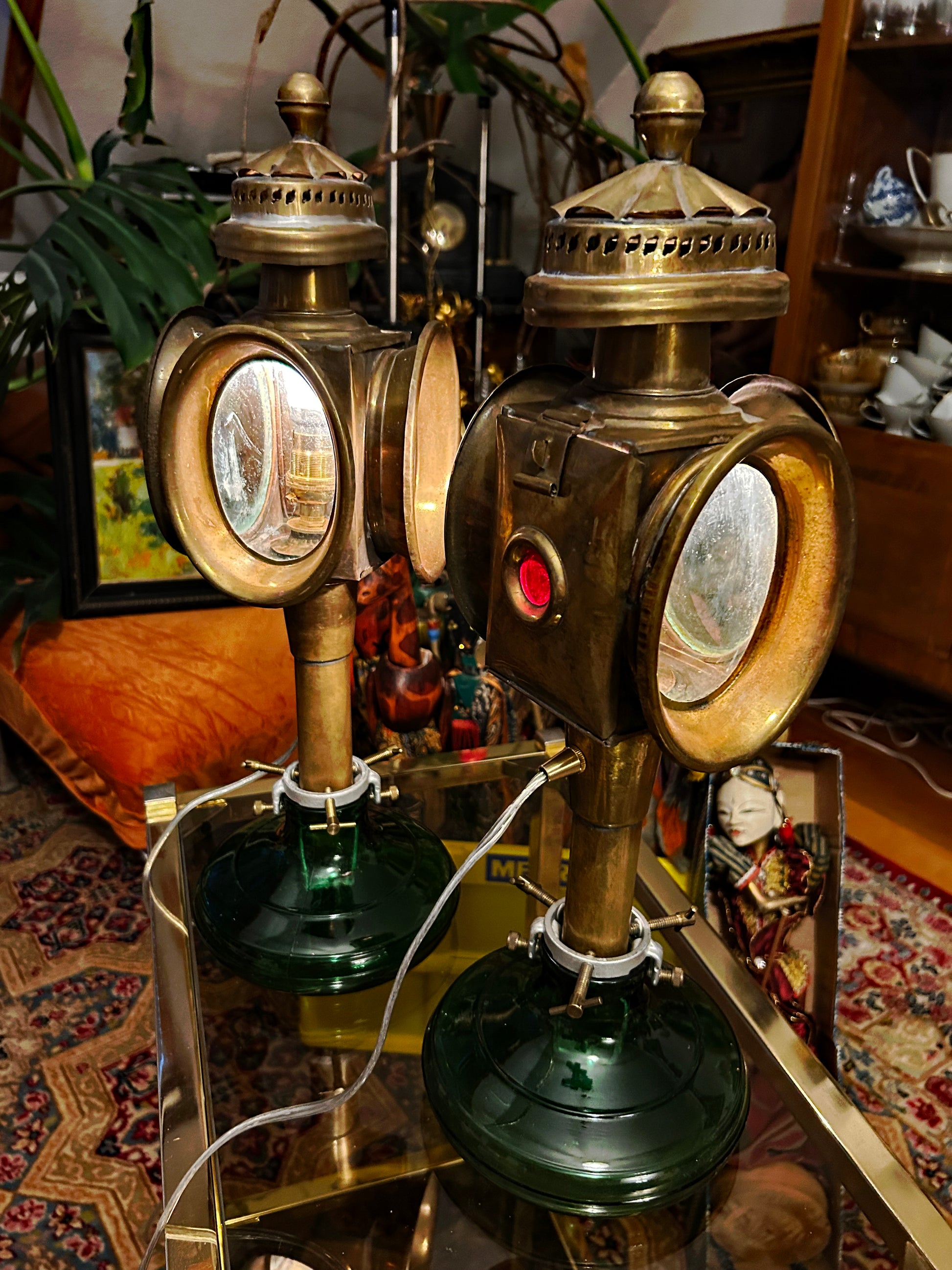 Both brass coach lamps standing on green glass bases, full view