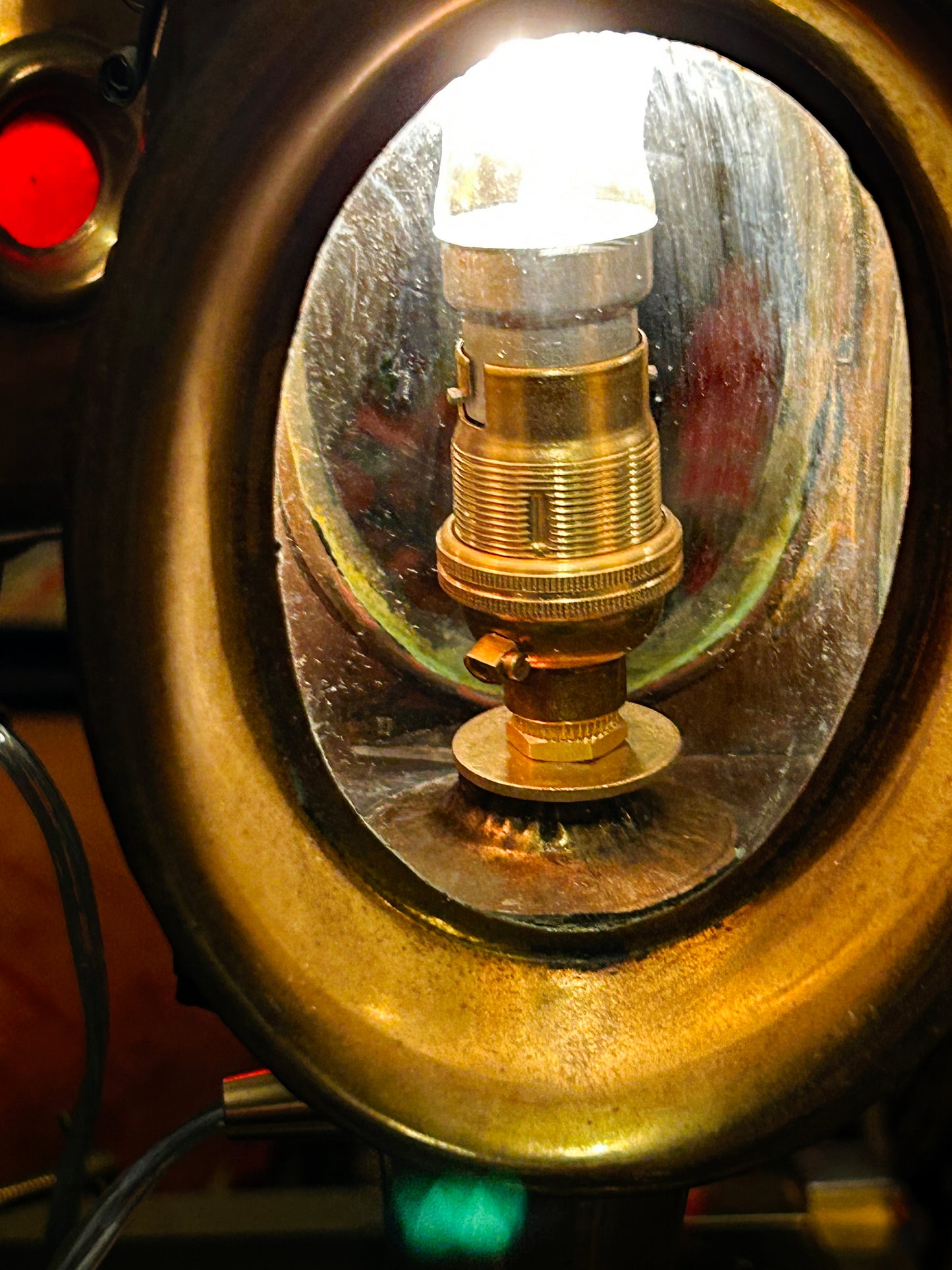 Electrified bulb fitting seen inside the brass reflector