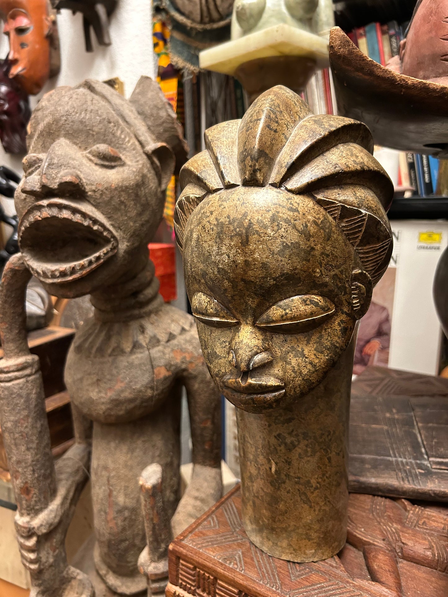 Profile angle of Benin-style stone head showing tiered braided coiffure and long neck
