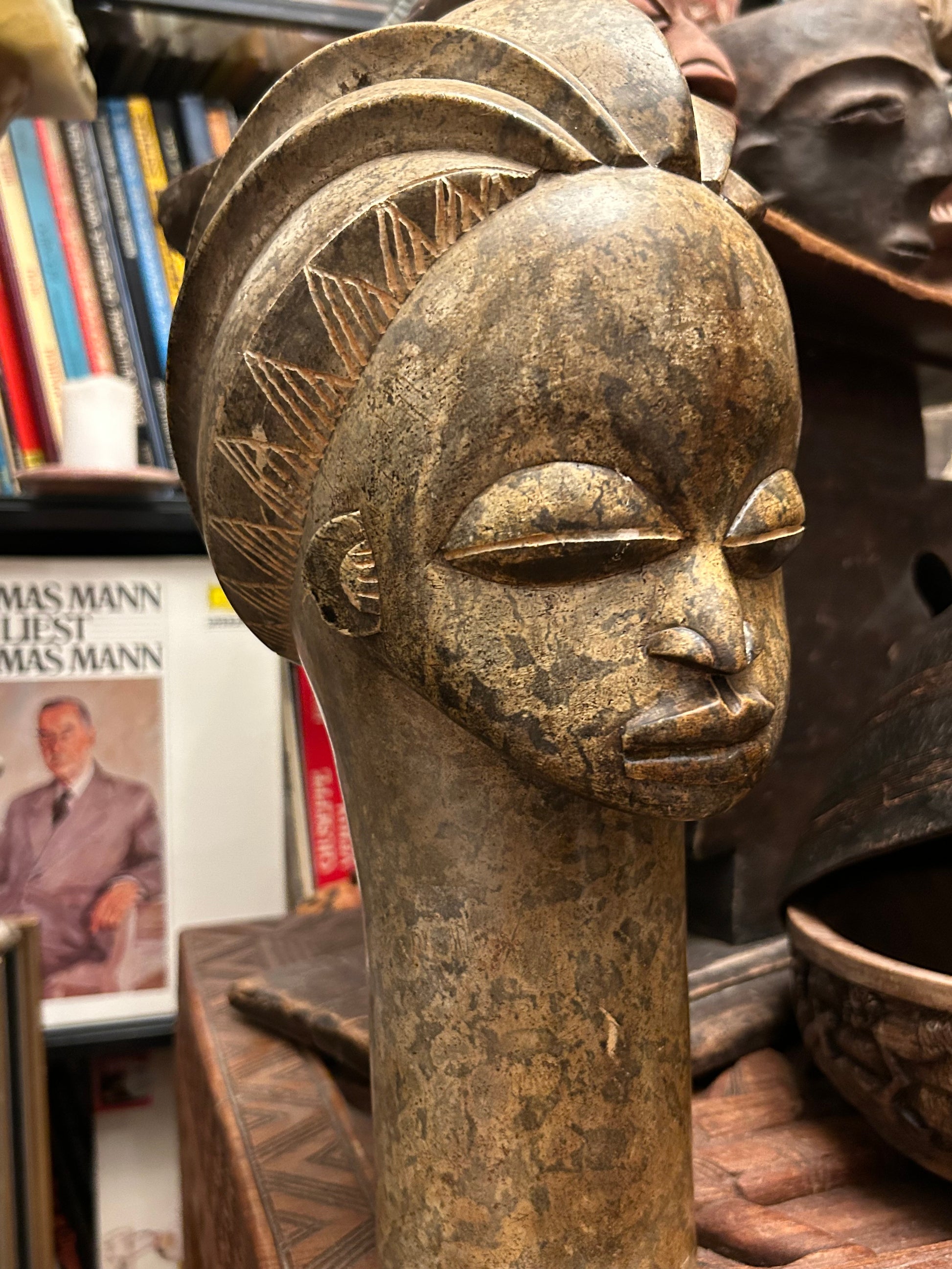 Benin-style stone head sculpture, close three-quarter view of serene downcast face and elongated neck