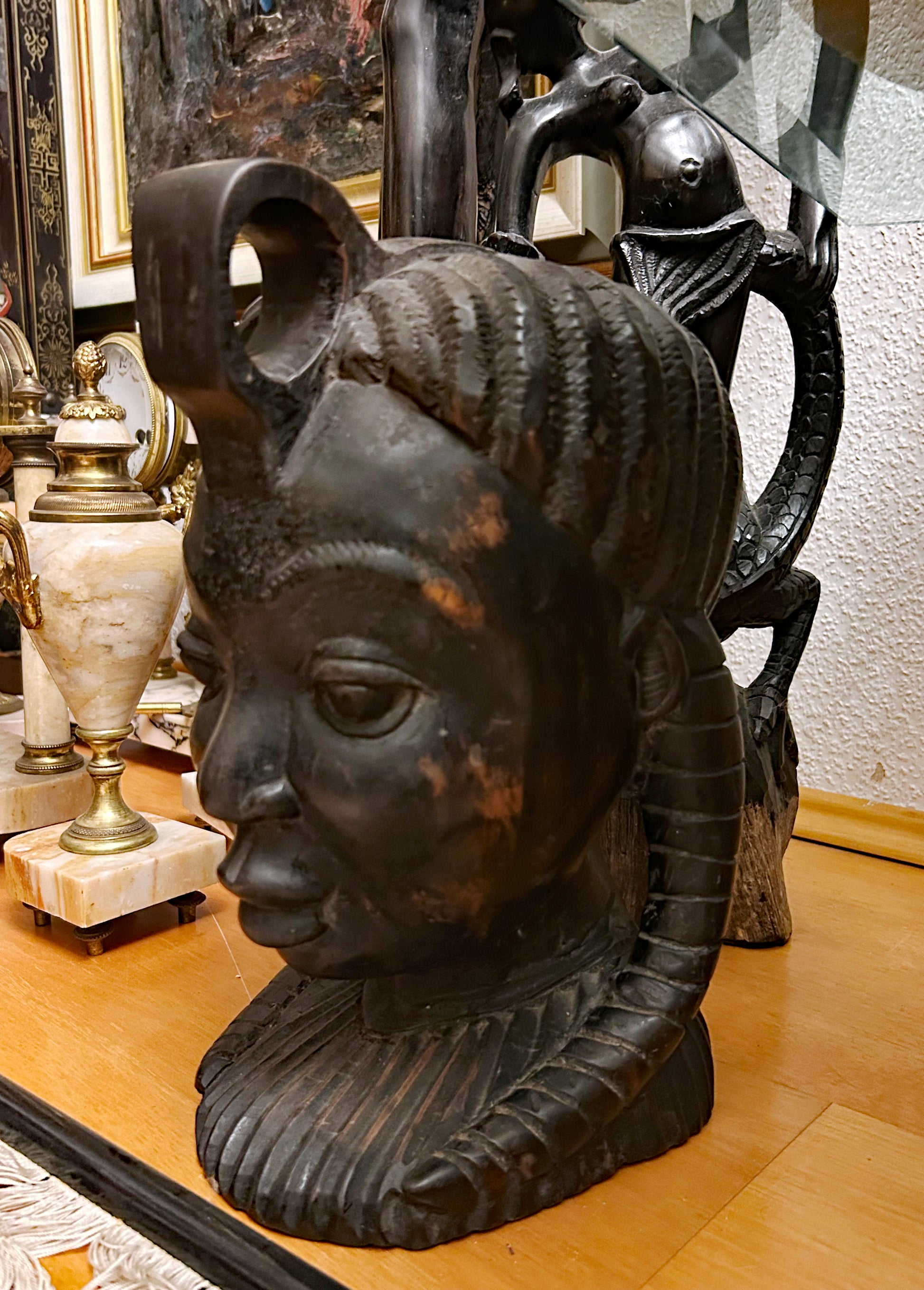 Side view of dark ebony African head sculpture full bust on console
