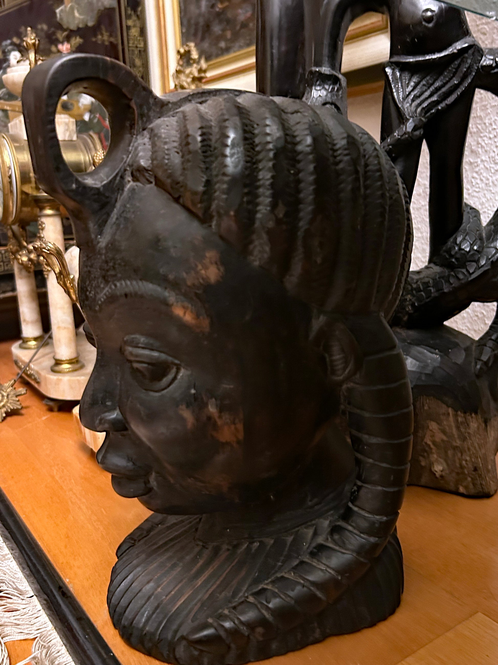 Large carved ebony African female head bust three-quarter view with braided coiffure