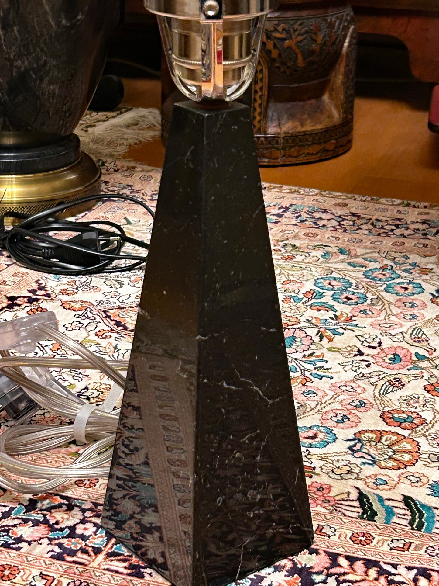 Close detail of the veined black marble obelisk base and chrome fitter