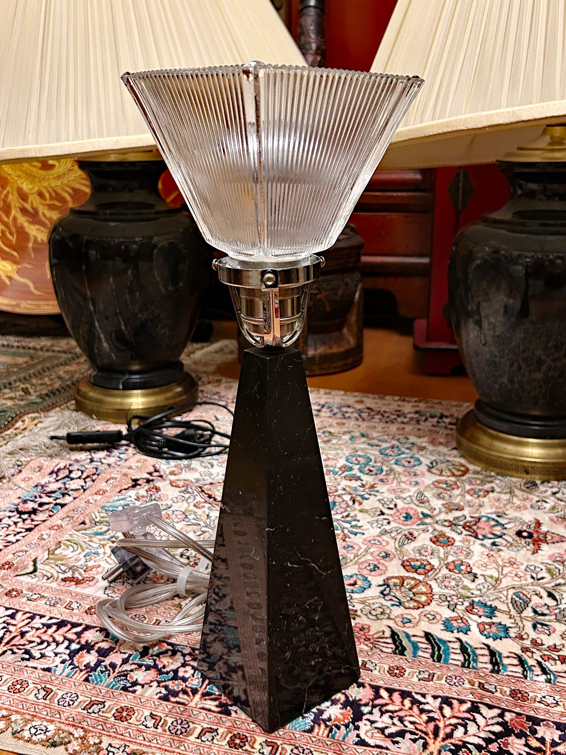 Black marble obelisk lamp with Holophane glass shade displayed in interior setting