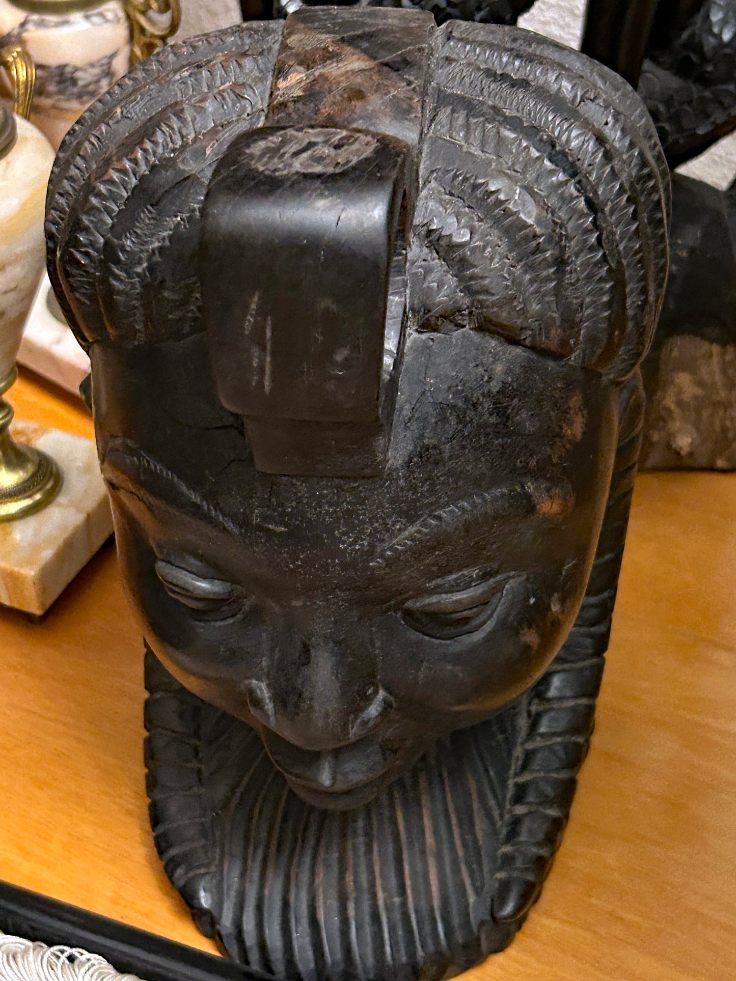 Top-down view of the sculptural braided coiffure and topknot of the ebony head