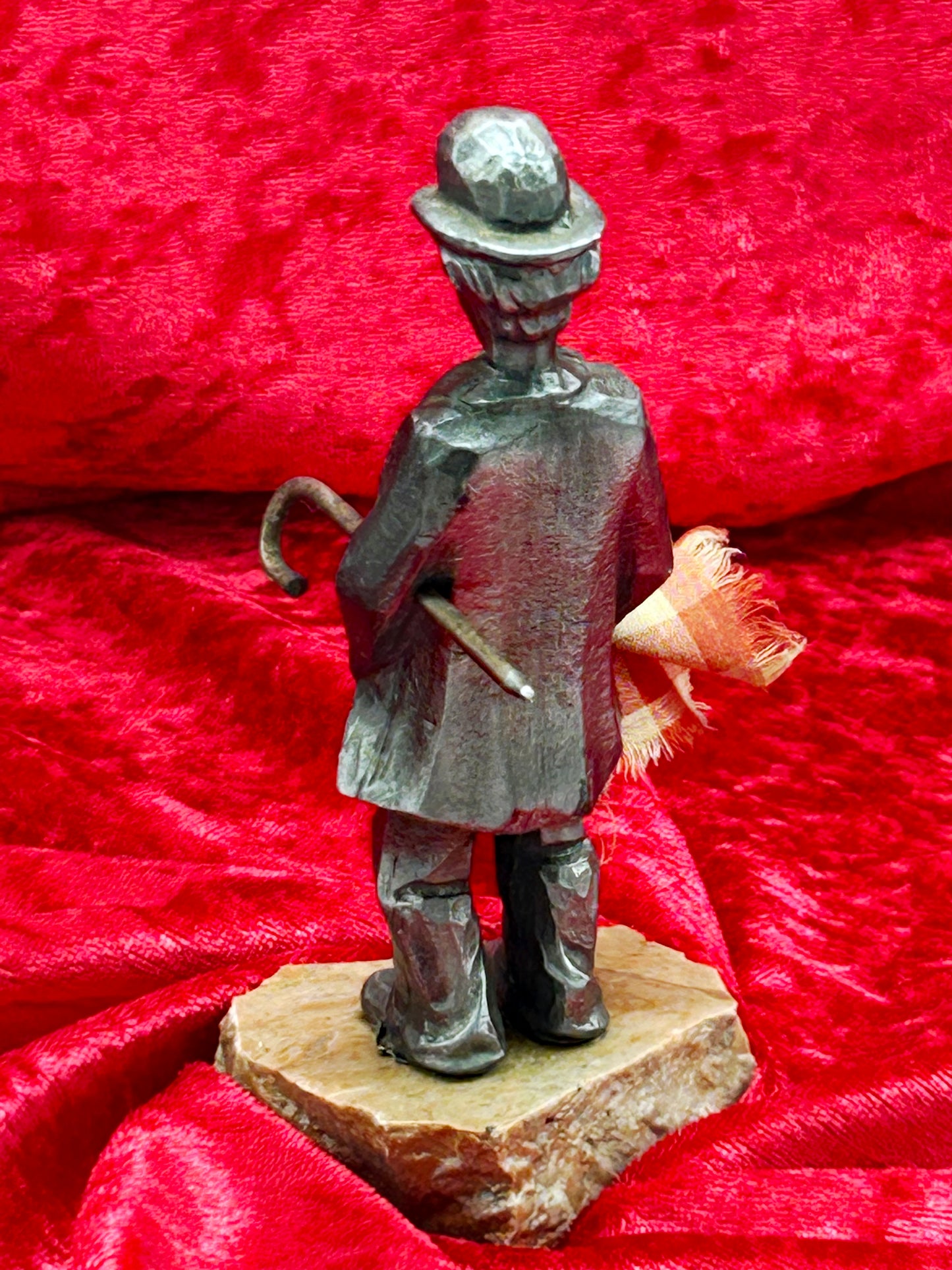 Rear view of silvered metal Chaplin figure on natural marble base