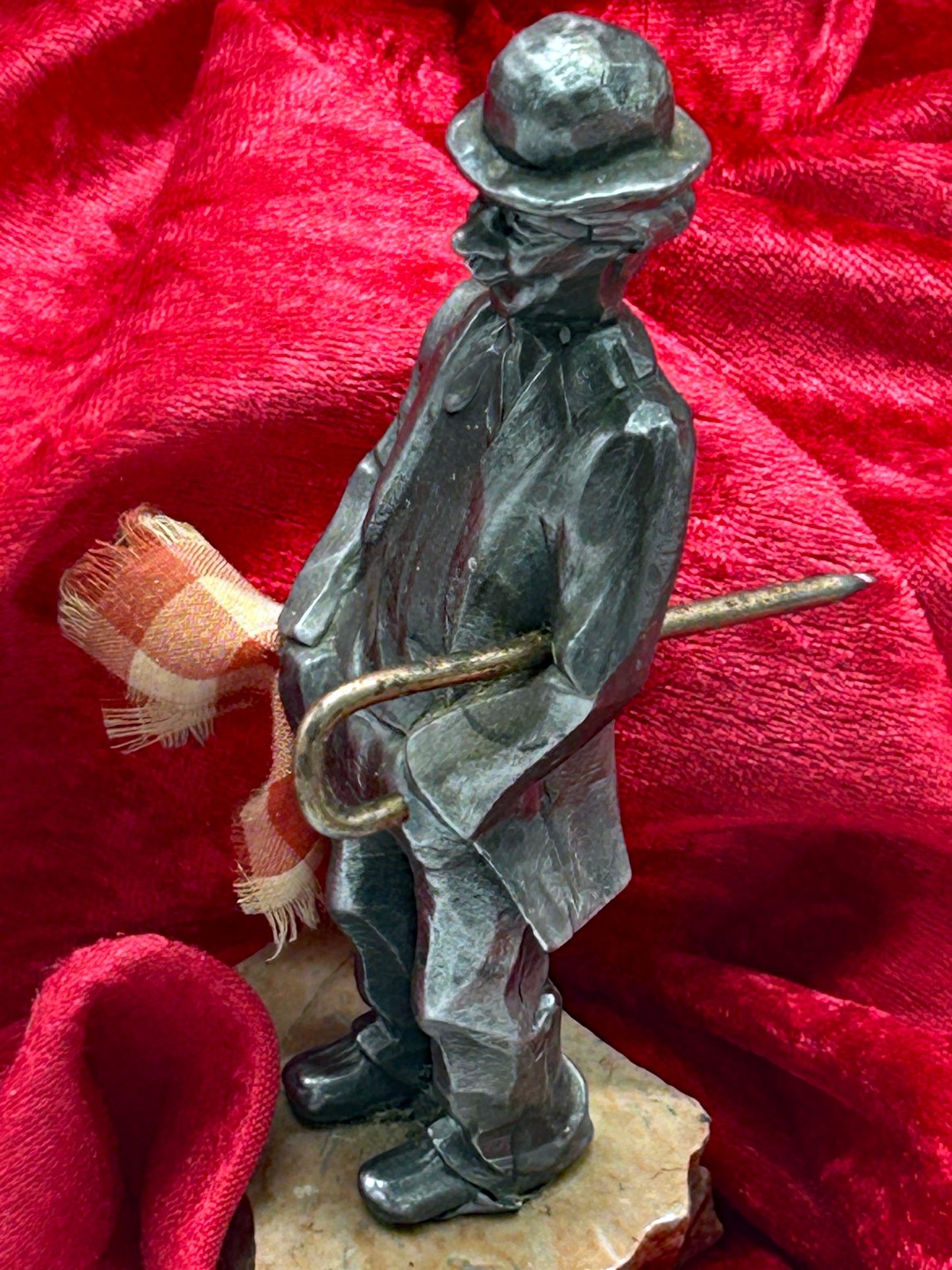 Silvered Chaplin figure side view showing cane, umbrella handle and checked scarf