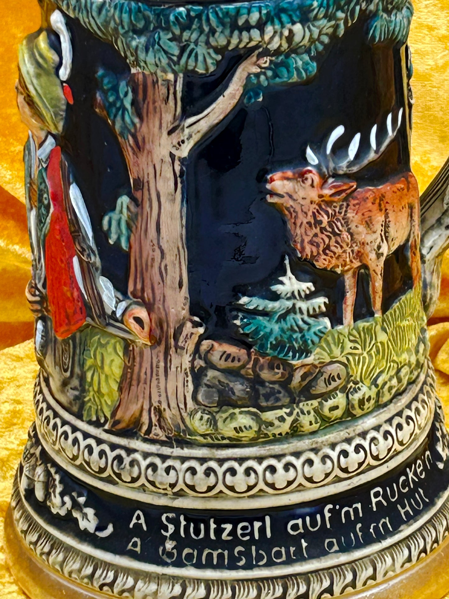 Close-up relief detail of stag in moonlit forest above carved inscription band