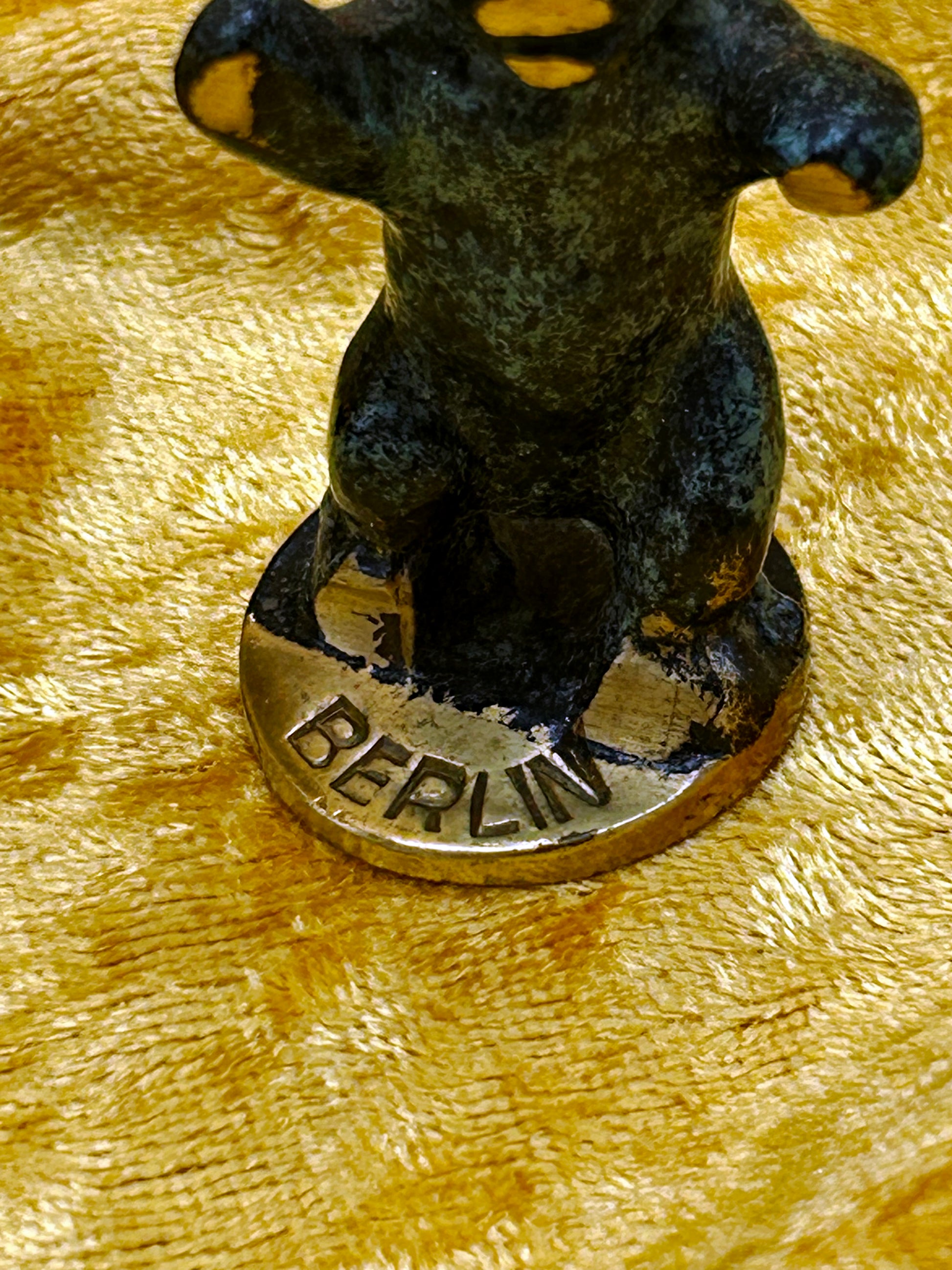 Close-up of BERLIN inscription stamped on the bronze coin-style base