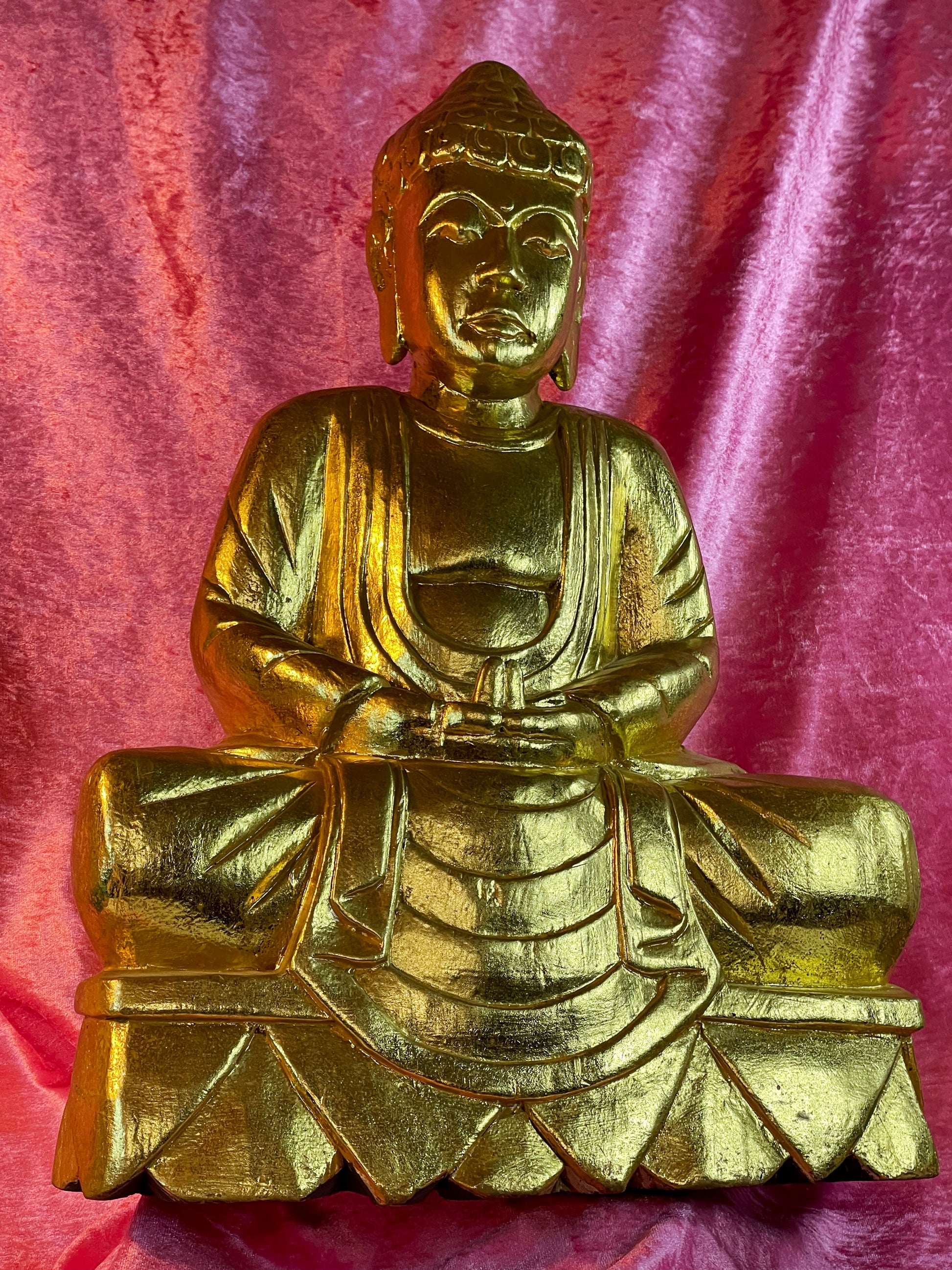 Hand-carved gold Buddha face and robe detail, angled view