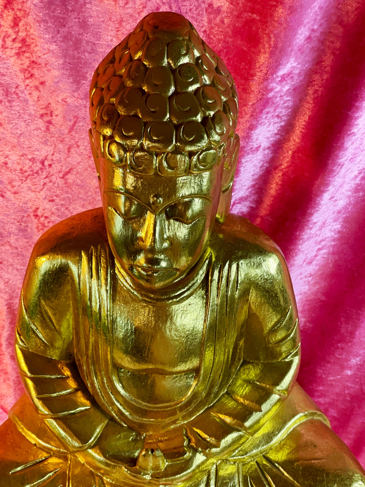 Serene gilded Buddha face and chest detail in meditation