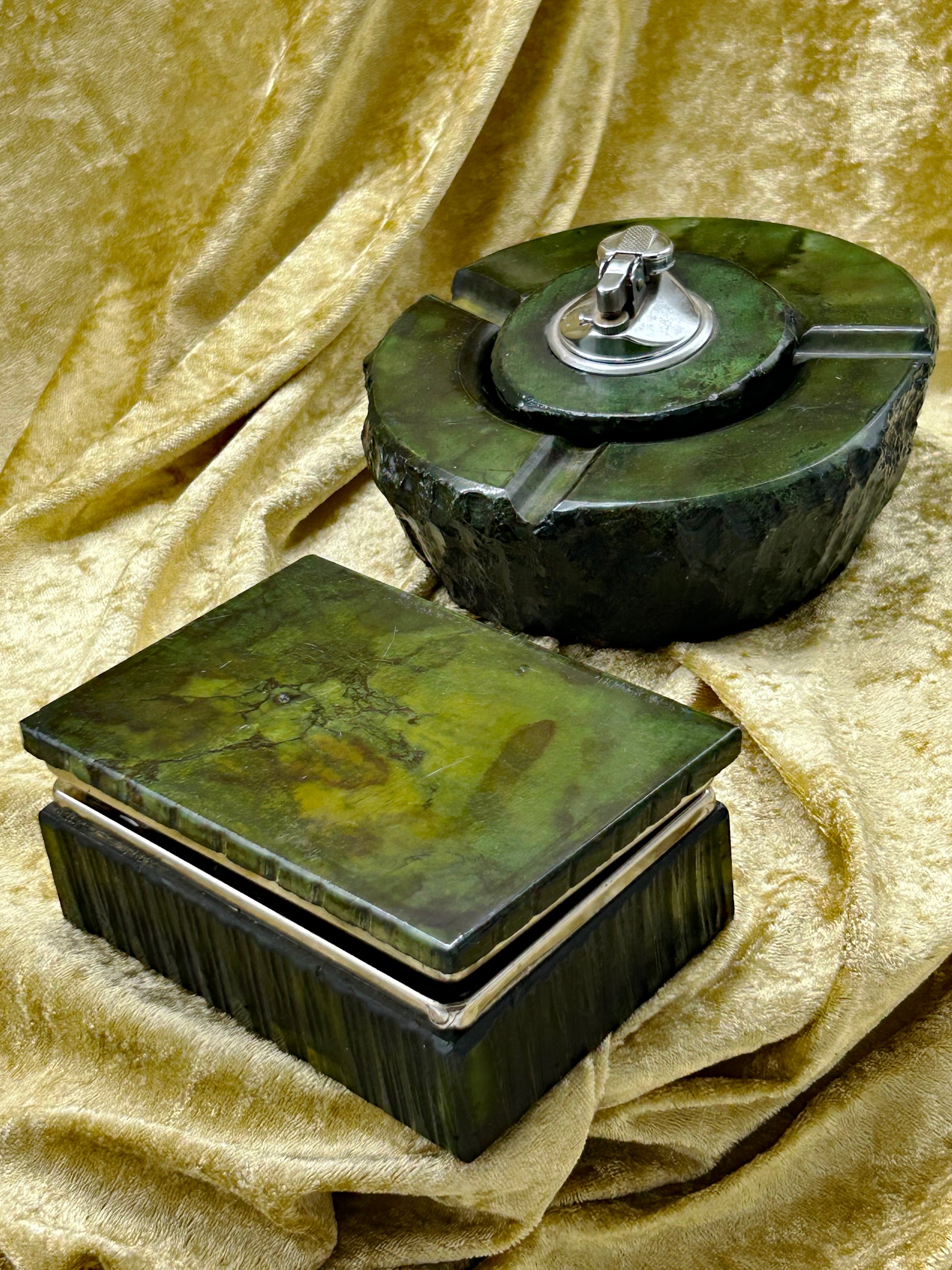 Green onyx marble ashtray with chrome table lighter beside lidded box, angled view