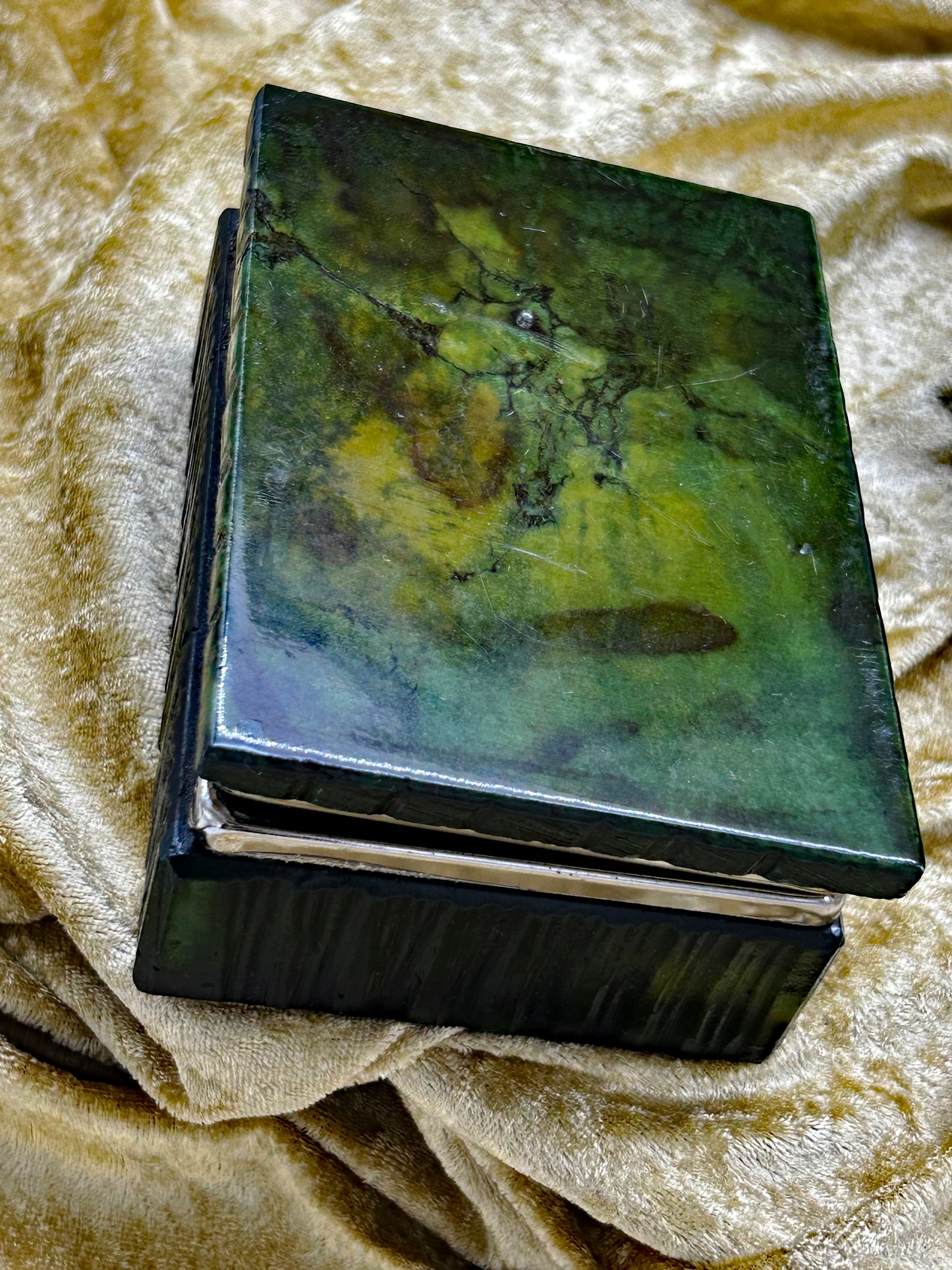 Close up of green onyx marble box lid showing emerald and ochre veining