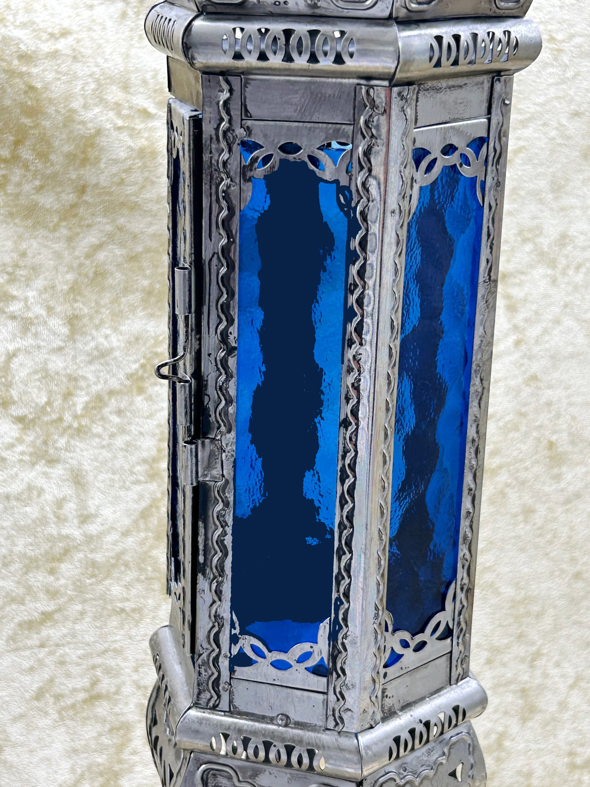 Close detail of cobalt blue rippled glass and silvered fretwork