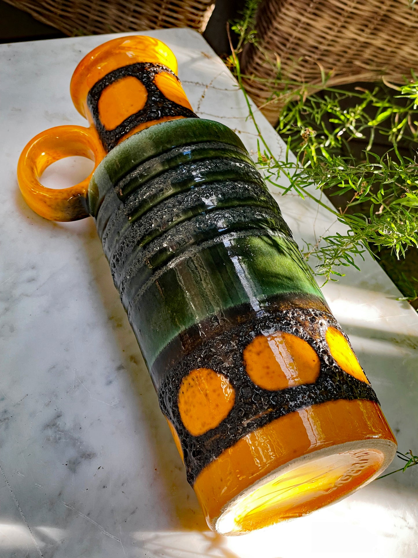Close angle of striped green glaze and textured black lava decoration