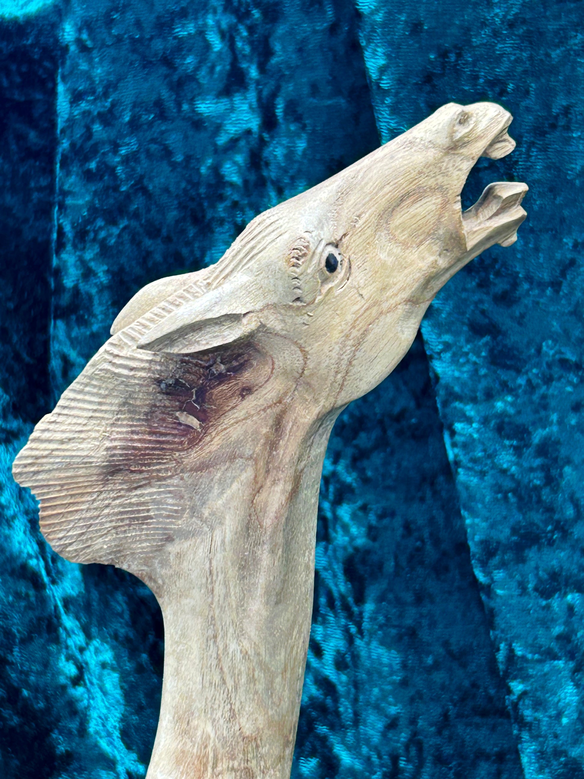 Alternate angle of the carved horse head highlighting flowing mane texture