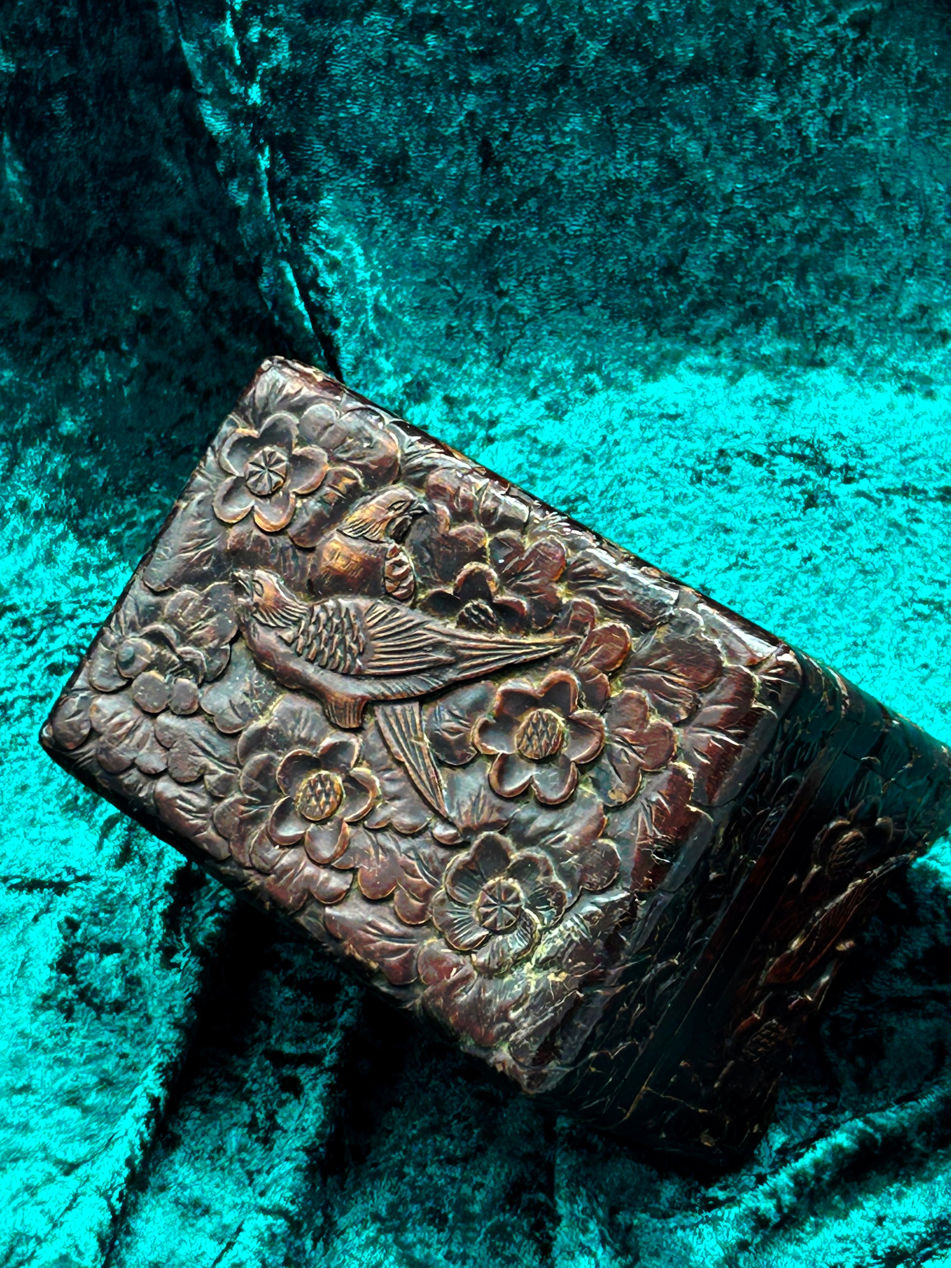Carved wooden box lid showing a pheasant gliding through cherry blossoms