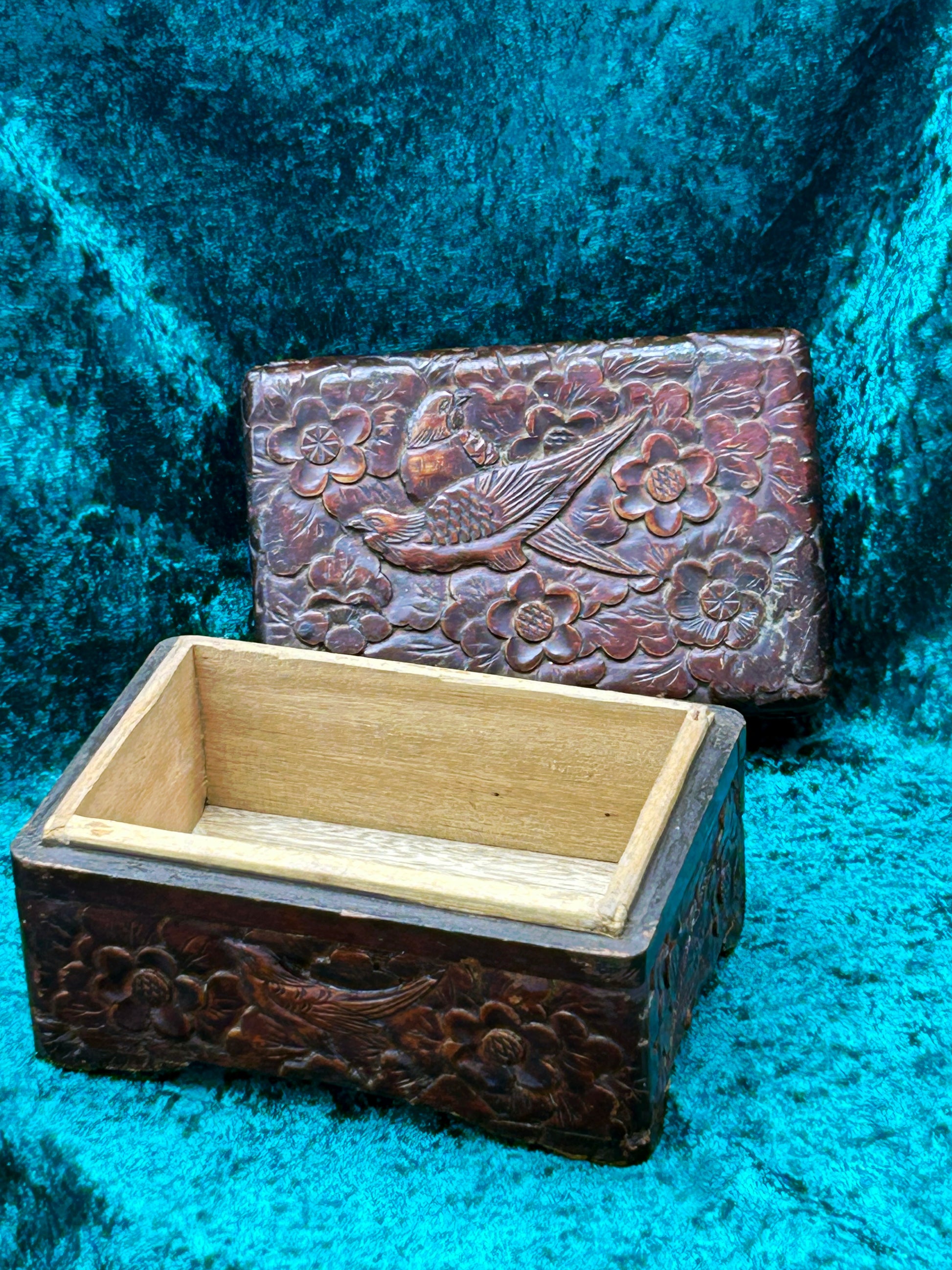 Carved wood box with lid removed showing the plain golden-toned interior