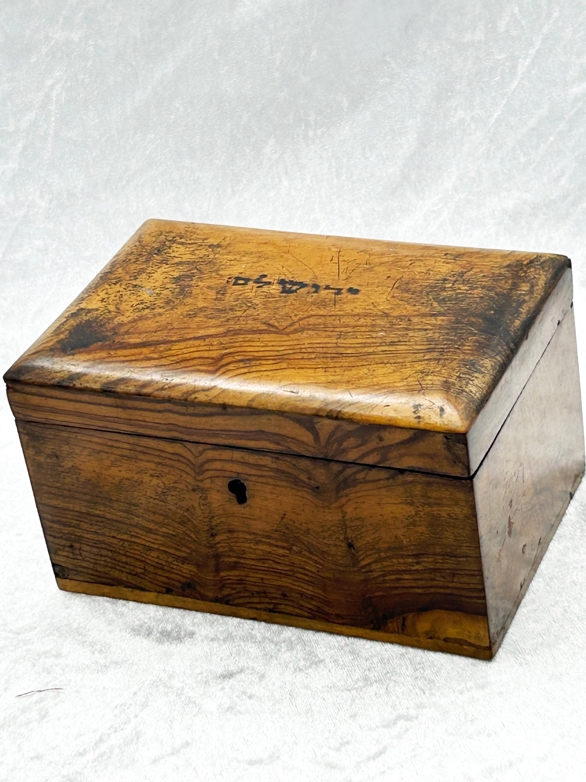 Antique olive wood box from Jerusalem, three-quarter view showing figured grain and brass keyhole