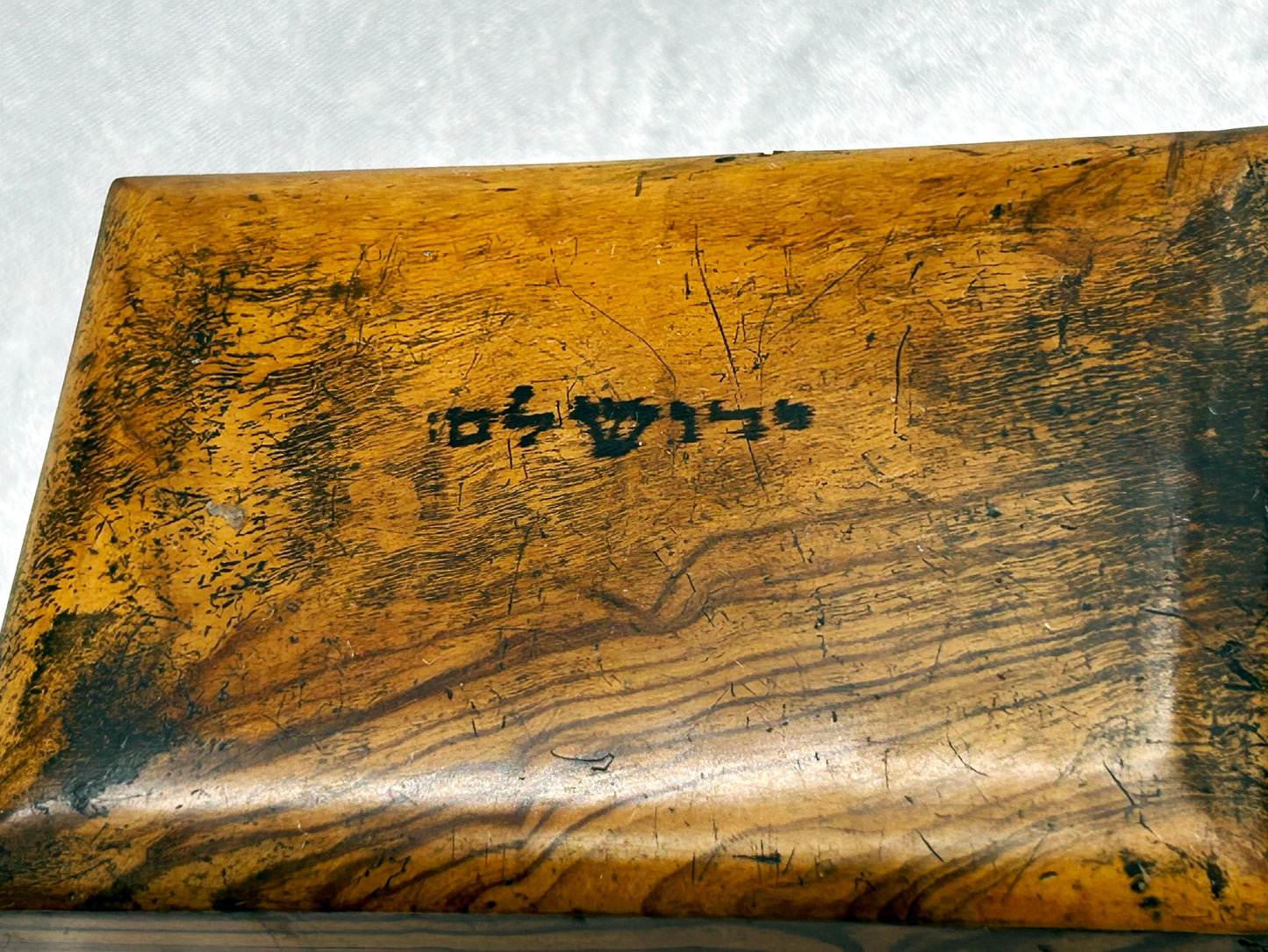 Close-up of the Hebrew lettering and grain on the box lid