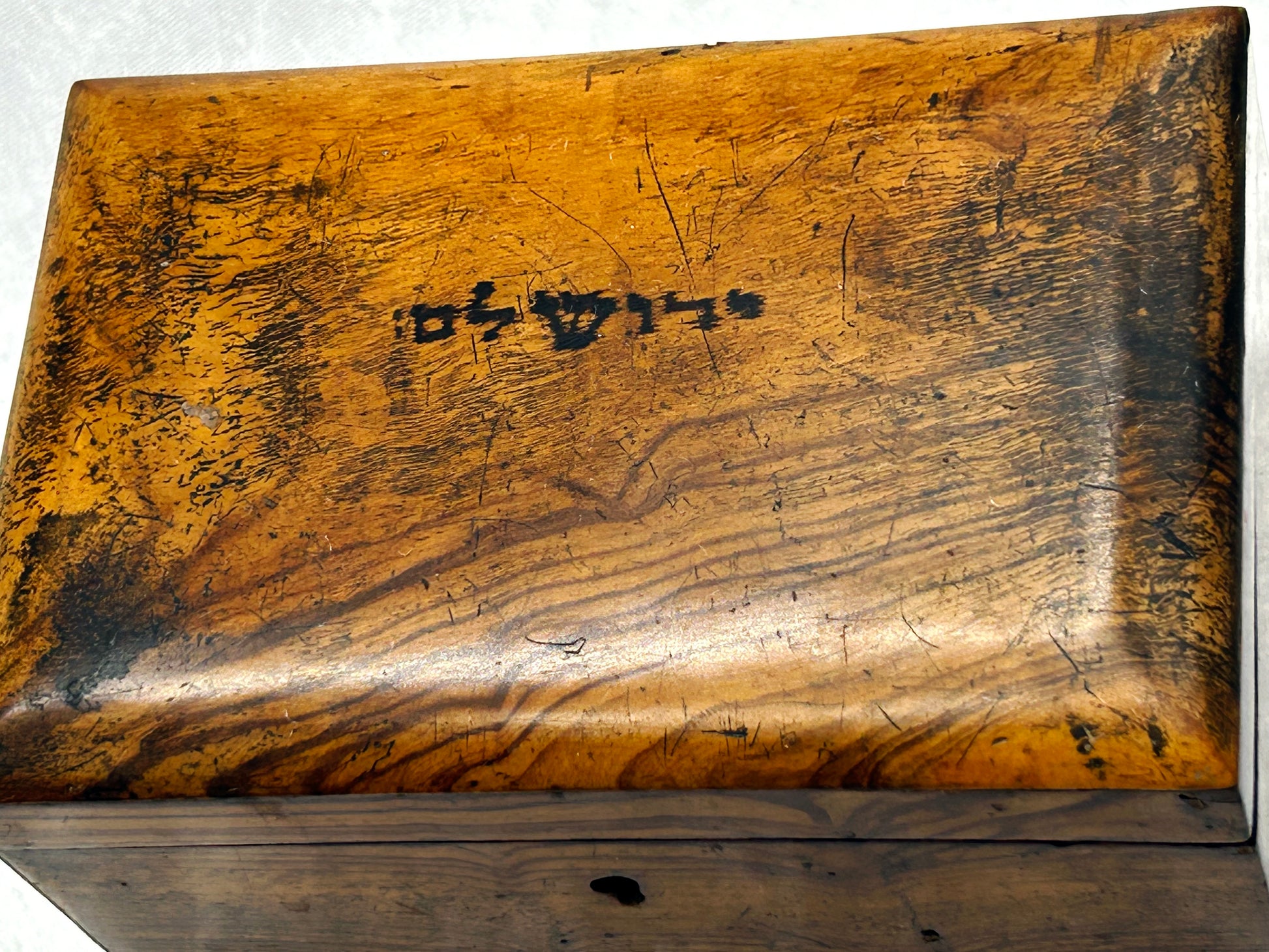 Top of the lid with inked Hebrew inscription on olive wood