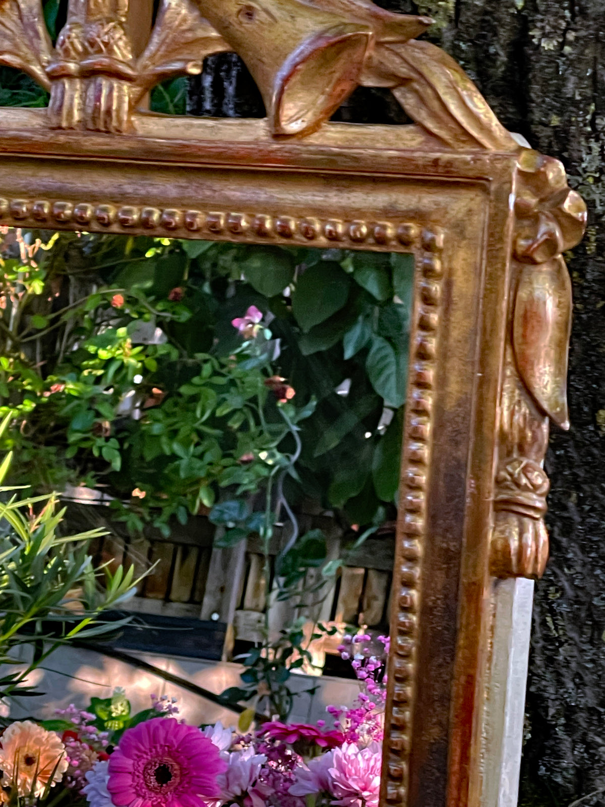 Carved gilt tassel and beaded moulding on the right side of the mirror frame