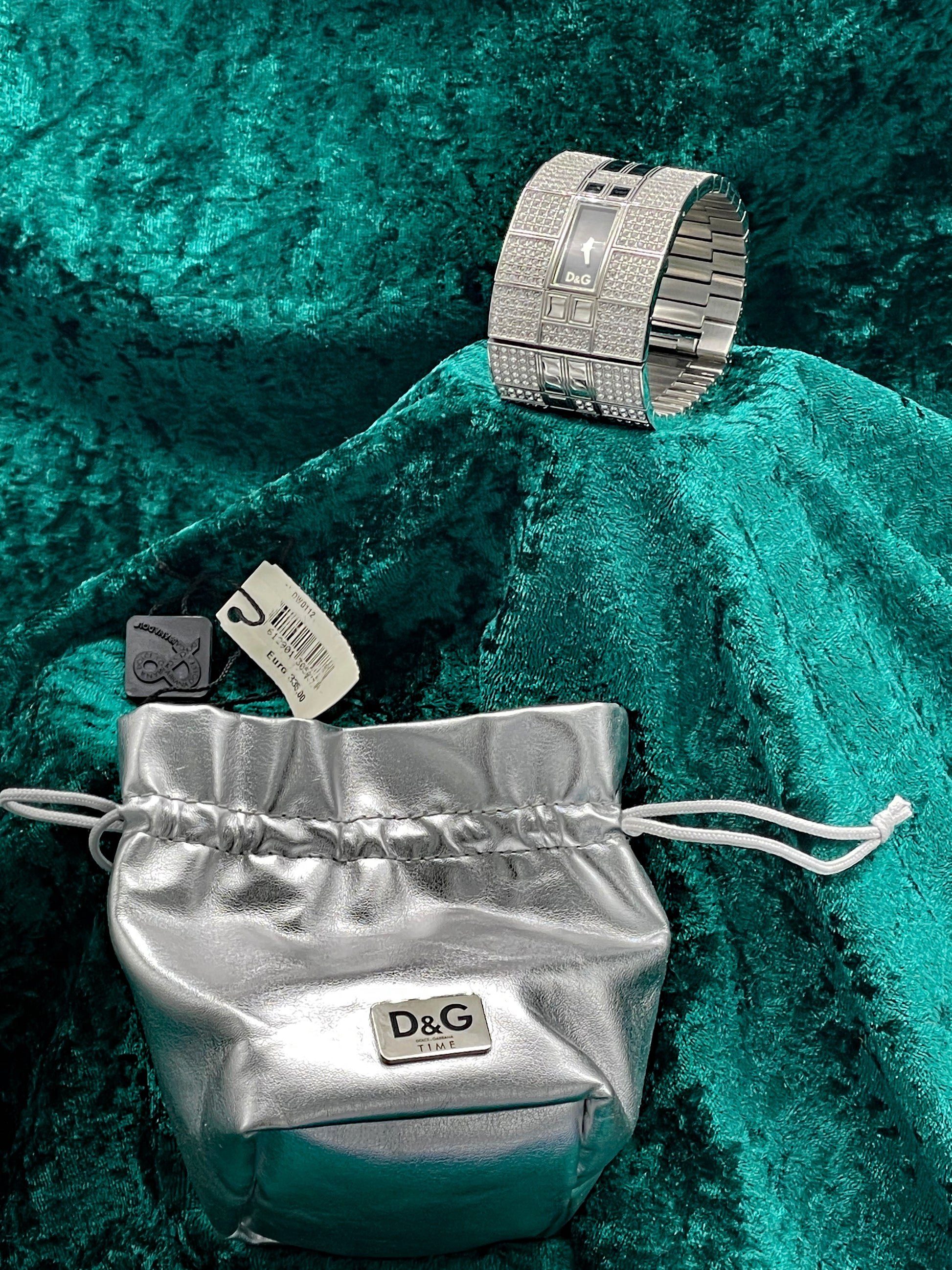 D&G Time cuff watch displayed beside its original silver drawstring pouch