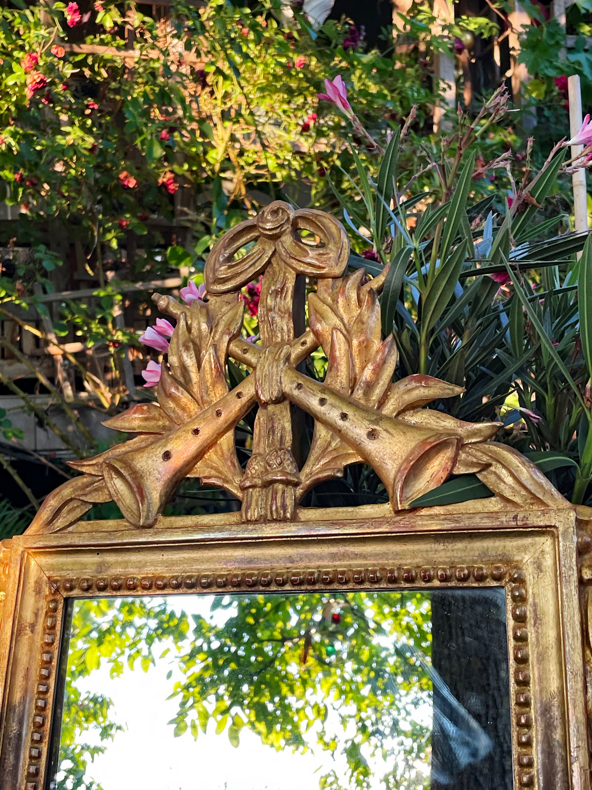 Upper carved wreath and ribbon bow of the giltwood Louis XVI mirror