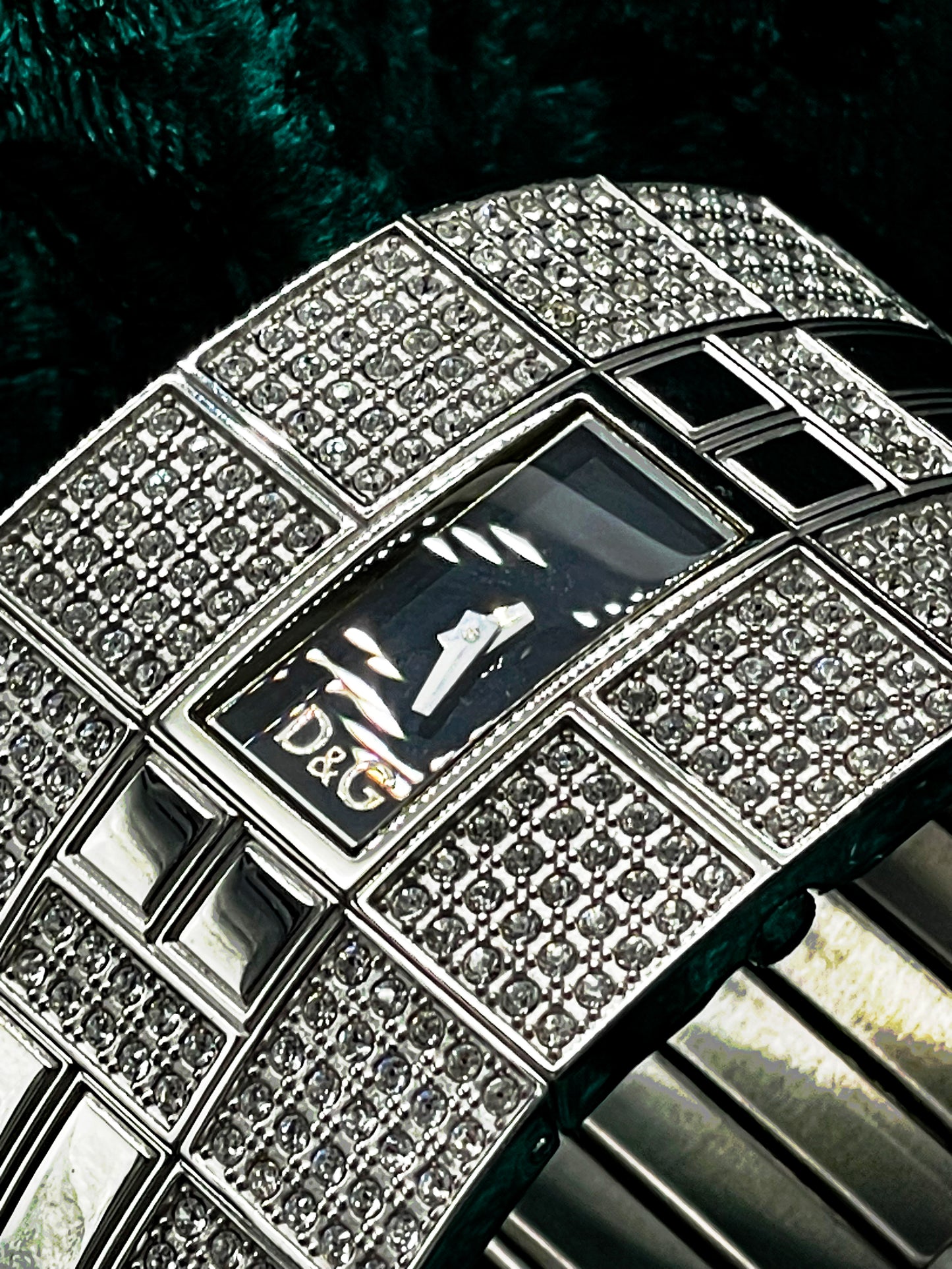 Macro of the black rectangular dial with applied D&G logo