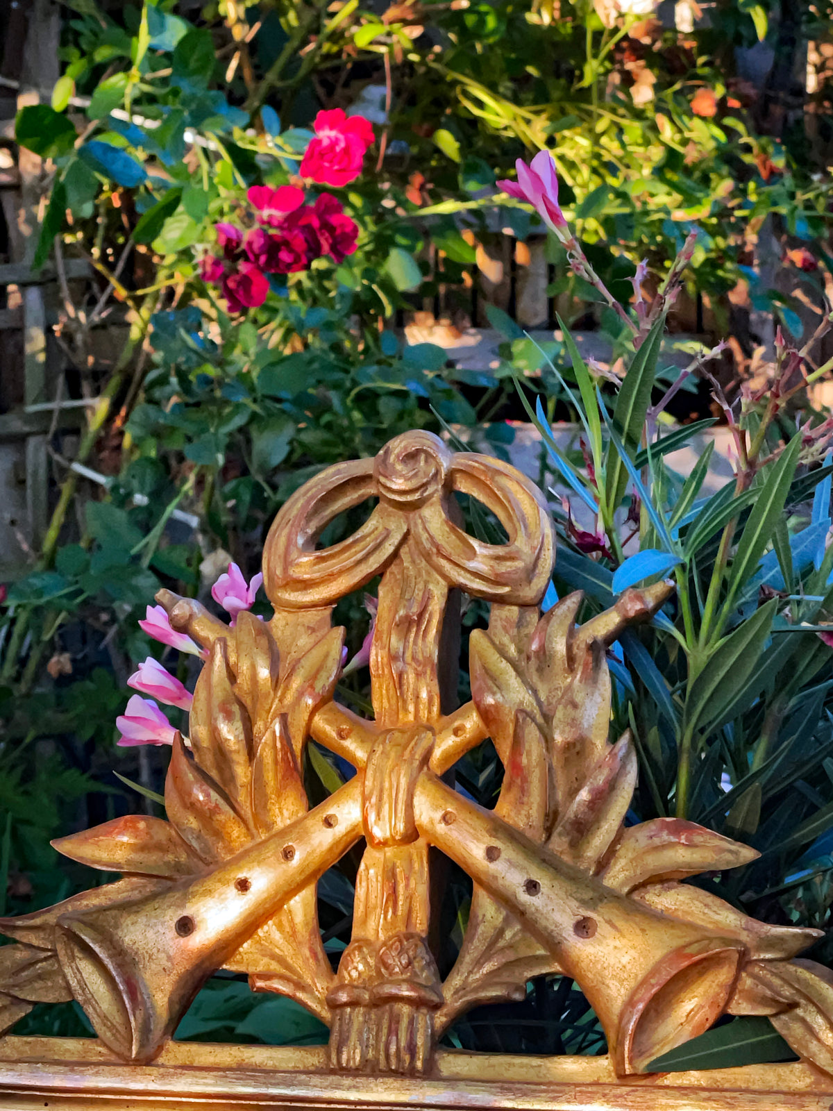 Detail of the gilded crossed trumpets and bow crowning the Louis XVI mirror