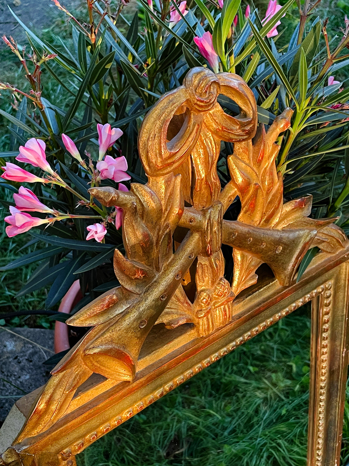 Carved giltwood crest of crossed hunting horns tied with a ribbon bow and laurel