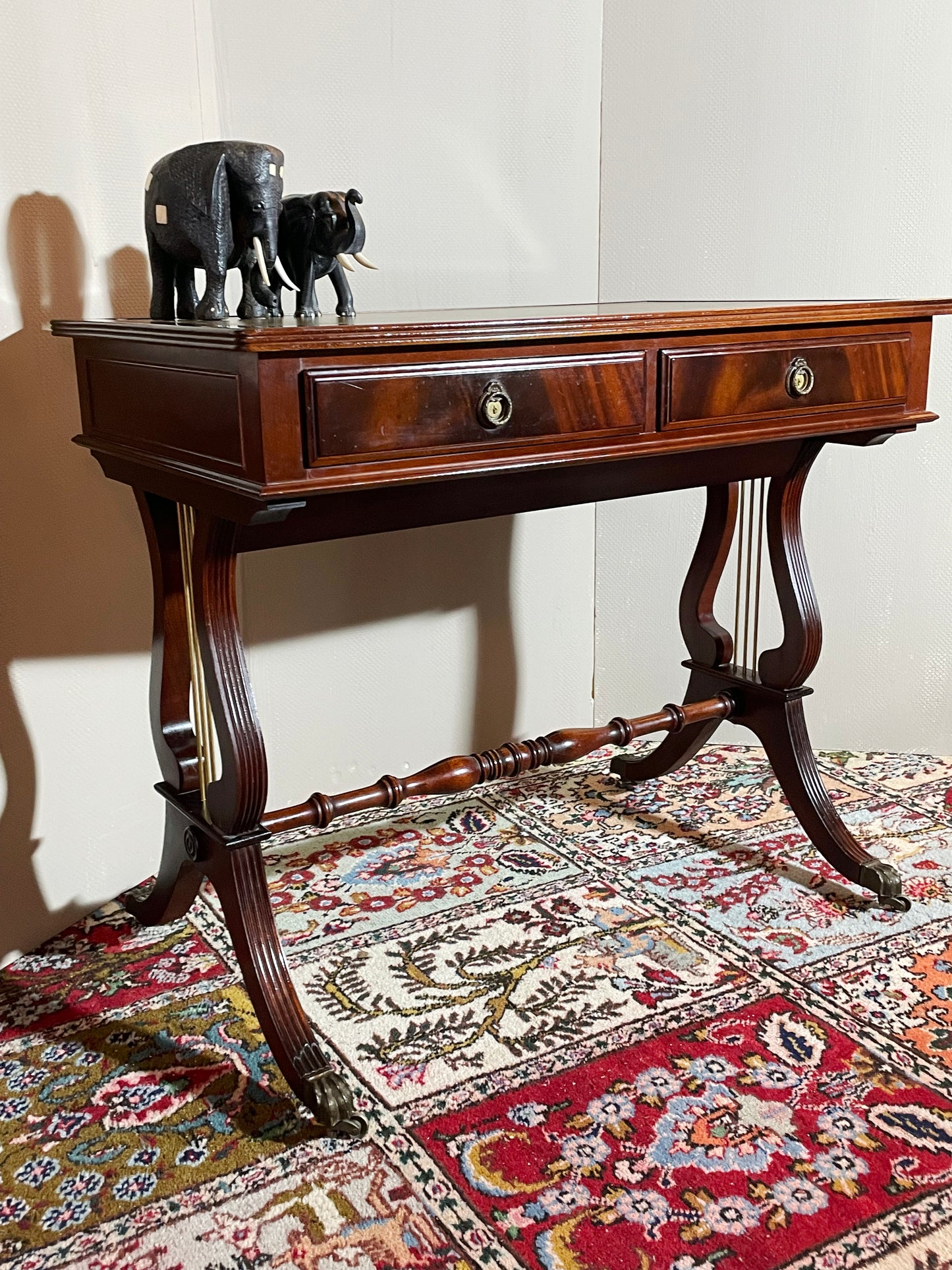 Mahogany lyre-end side table with two drawers and brass ring-pulls, front three-quarter view