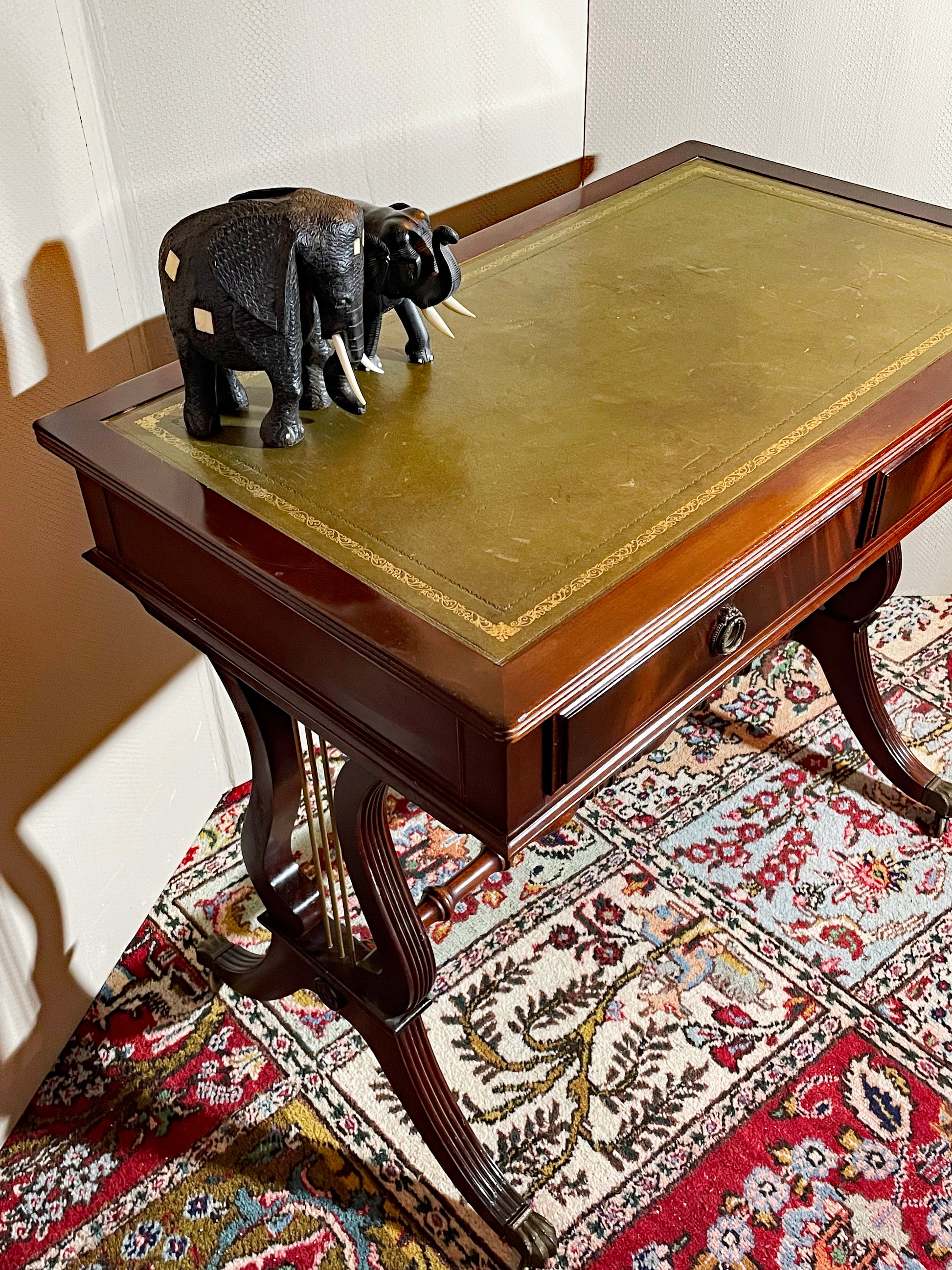 Hand-tooled green leather inset top with gilt border on mahogany console table