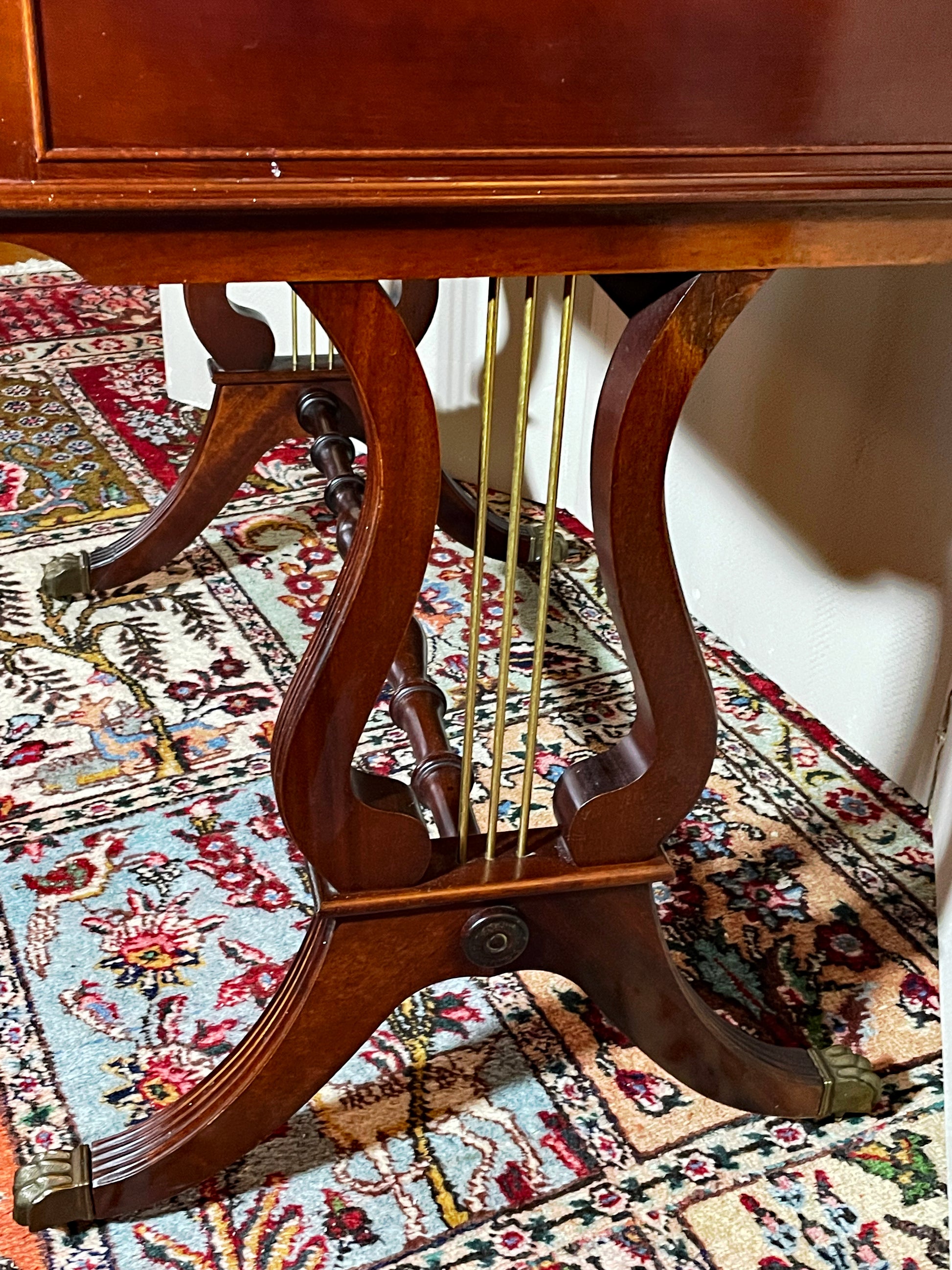 Carved mahogany lyre-form end standard strung with brass rods and reeded sabre leg