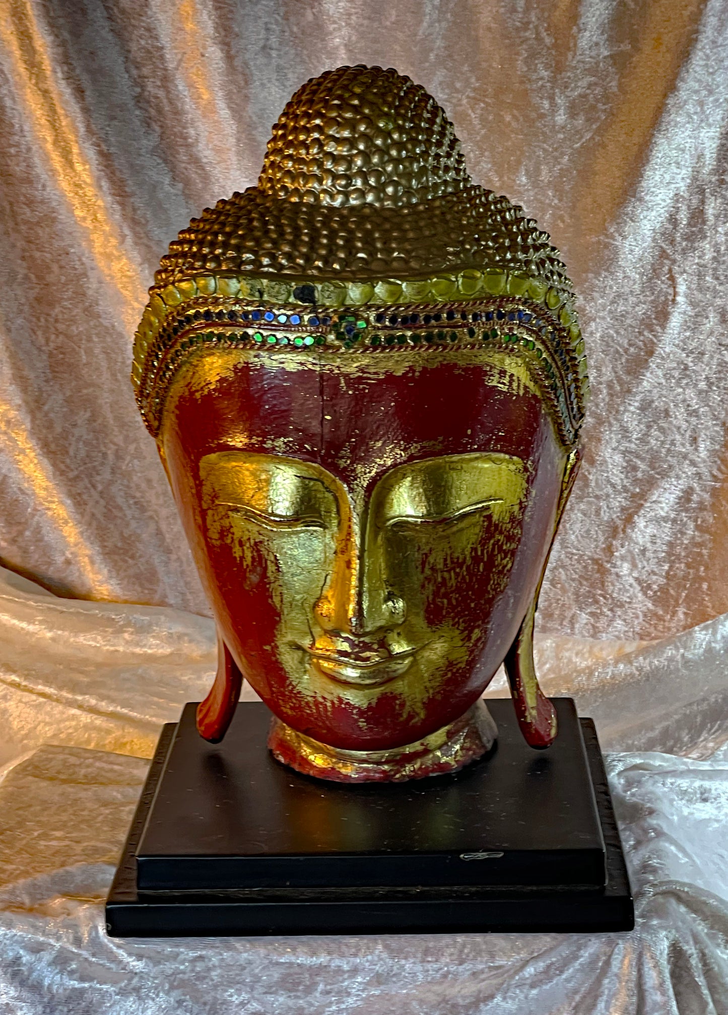 Antique red lacquer and gilt wood Buddha head sculpture, frontal view on black wooden stand
